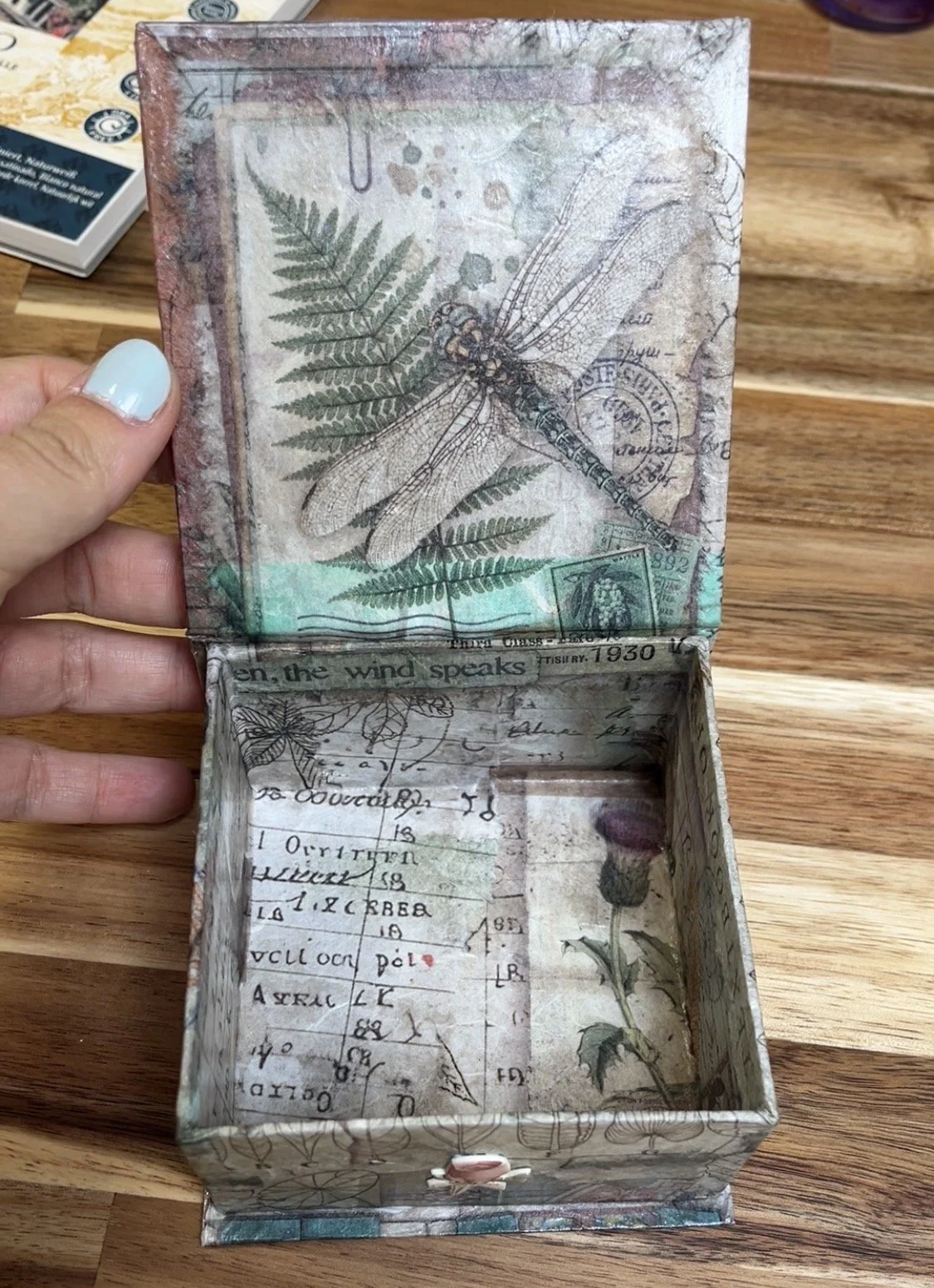 Interior de caja recordatorio personalizada en tonos gris y azul, detalle artesanal hecho a mano