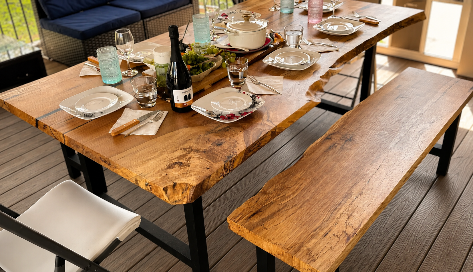 Live-edge pecan wood dining table and matching bench, set for a meal on an outdoor deck