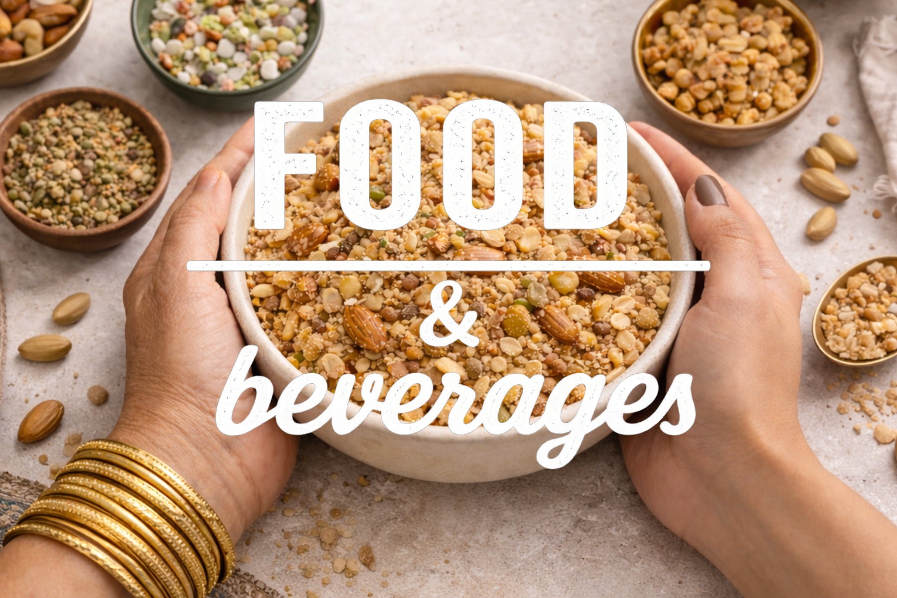 Hands holding a bowl of mixed seeds and grains surrounded by bowls of various seeds, with gold bangles on wrist, on a light surface.