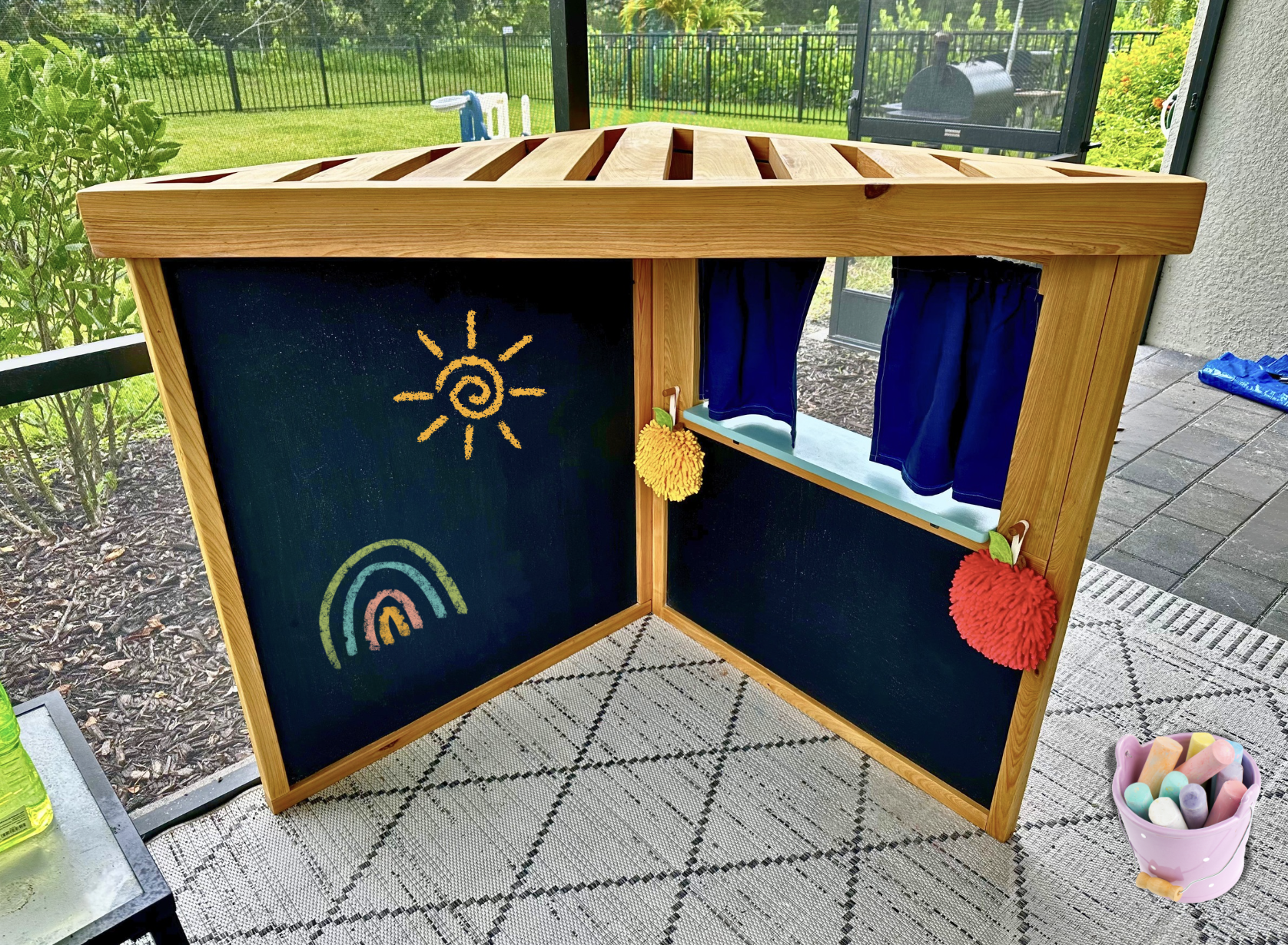 OUTDOOR CREATIVE PLAY CORNER, St. Pete, FL | The reverse side of this two-sided toddler play station features two chalkboard panels, ready for hours of creativity. Built from cypress with a durable exterior sealer, made to live outside and handle rea