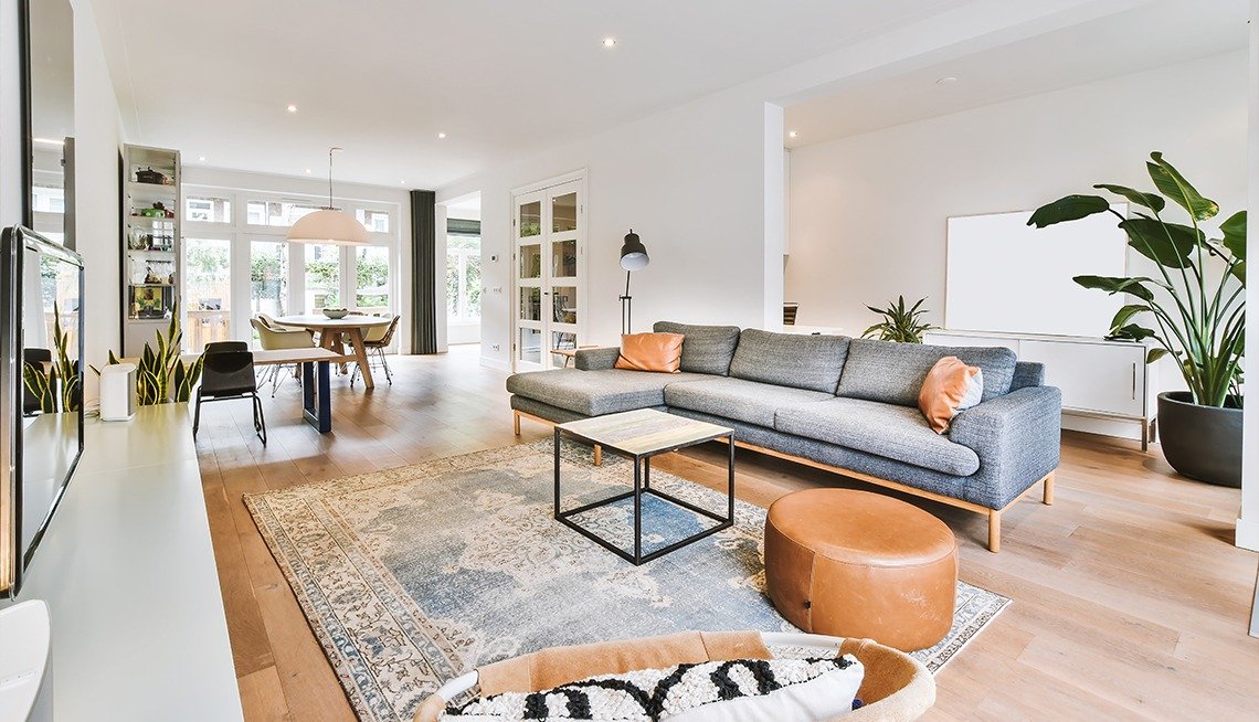 Modern living room with a gray sectional sofa, round leather ottoman, coffee table and patterned area rug after it was cleaned in Columbus, Ohio.