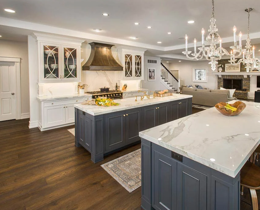 Modern and elegant open-concept kitchen with white and navy blue cabinets and marble countertops after it was cleaned by Columbus Cleaning Service
