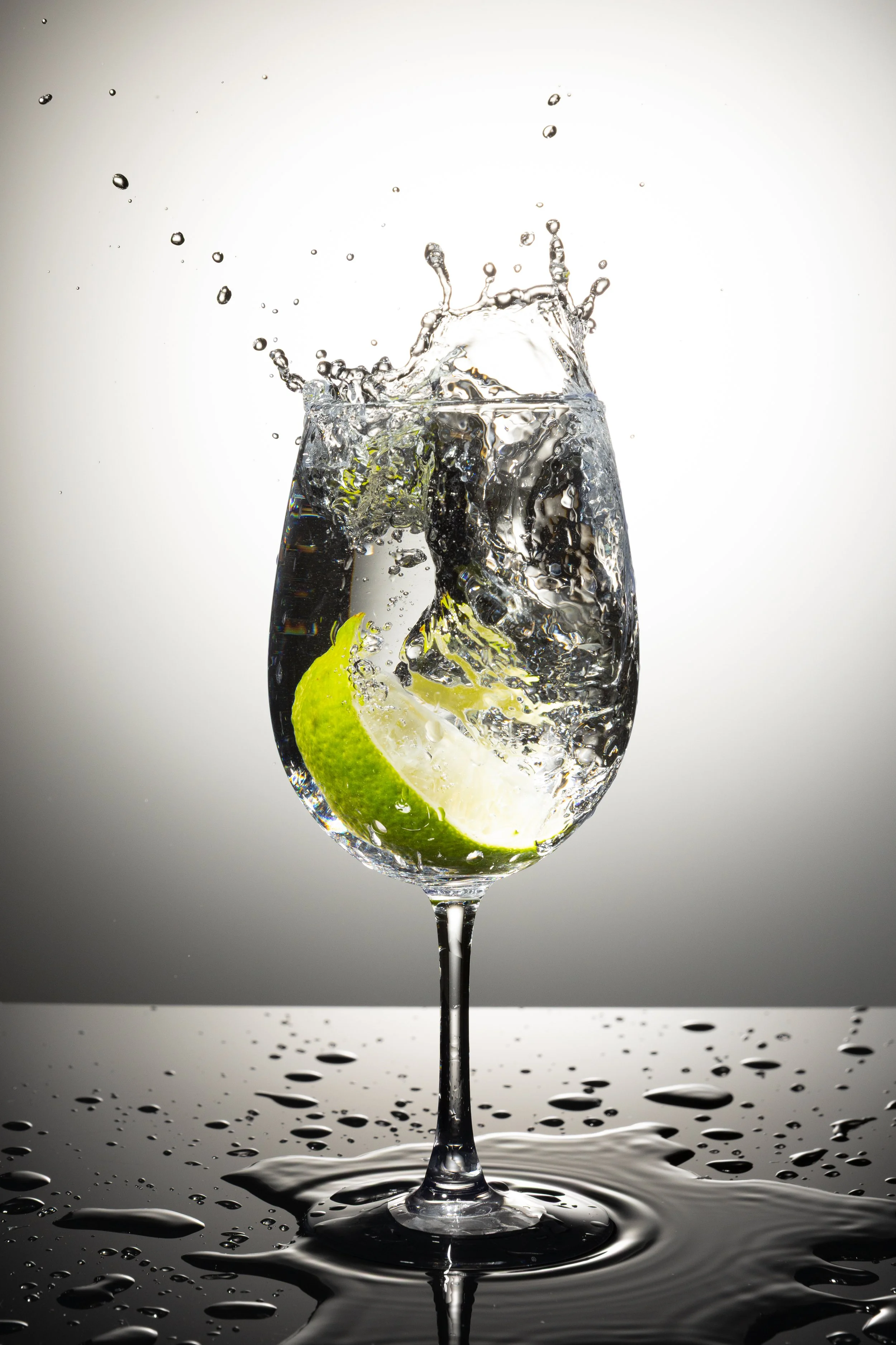 Product studio photo of splash water with food lime against a clean backdrop high resolution