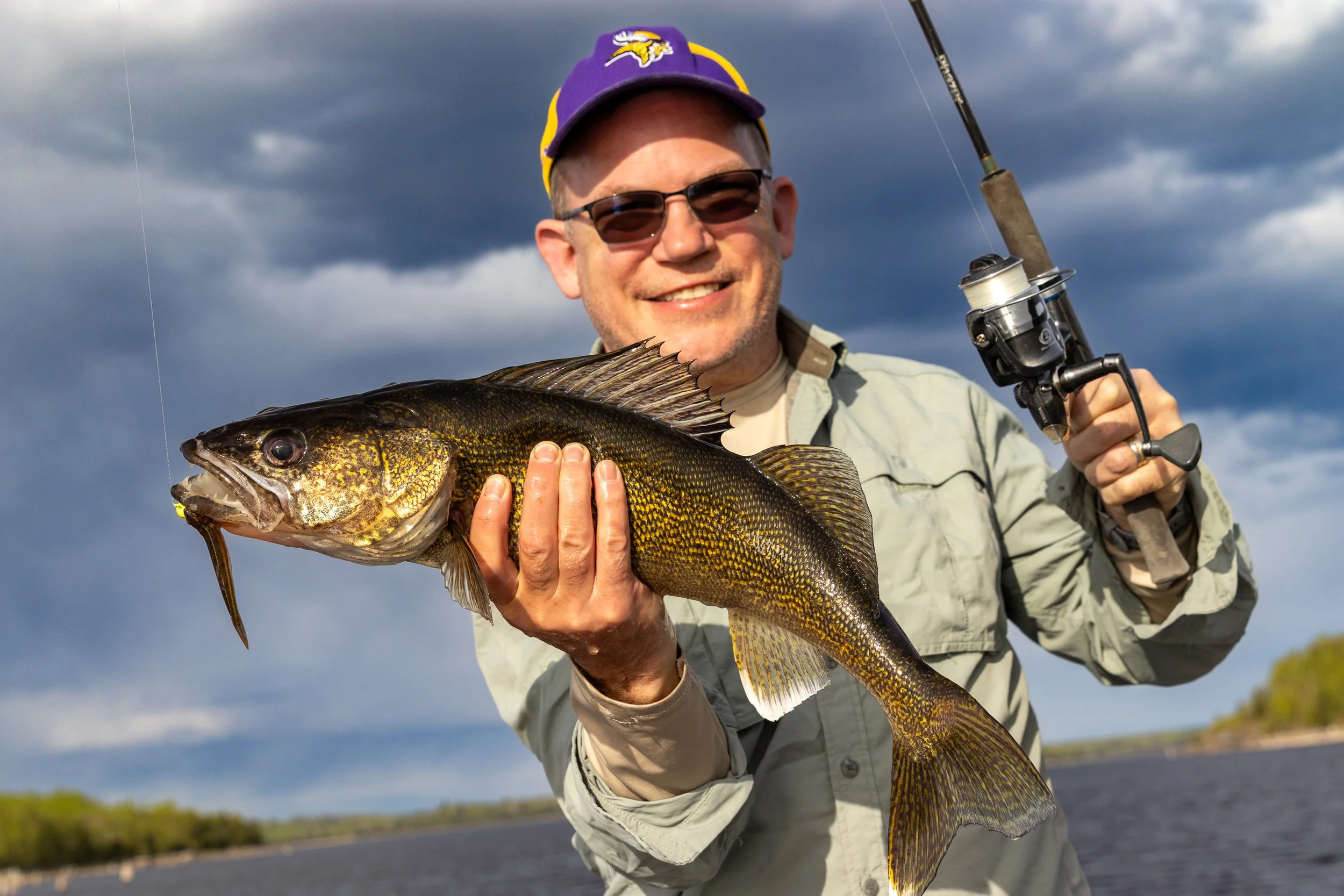 Professional photo headshot of man holding fish well lit in Menomonie