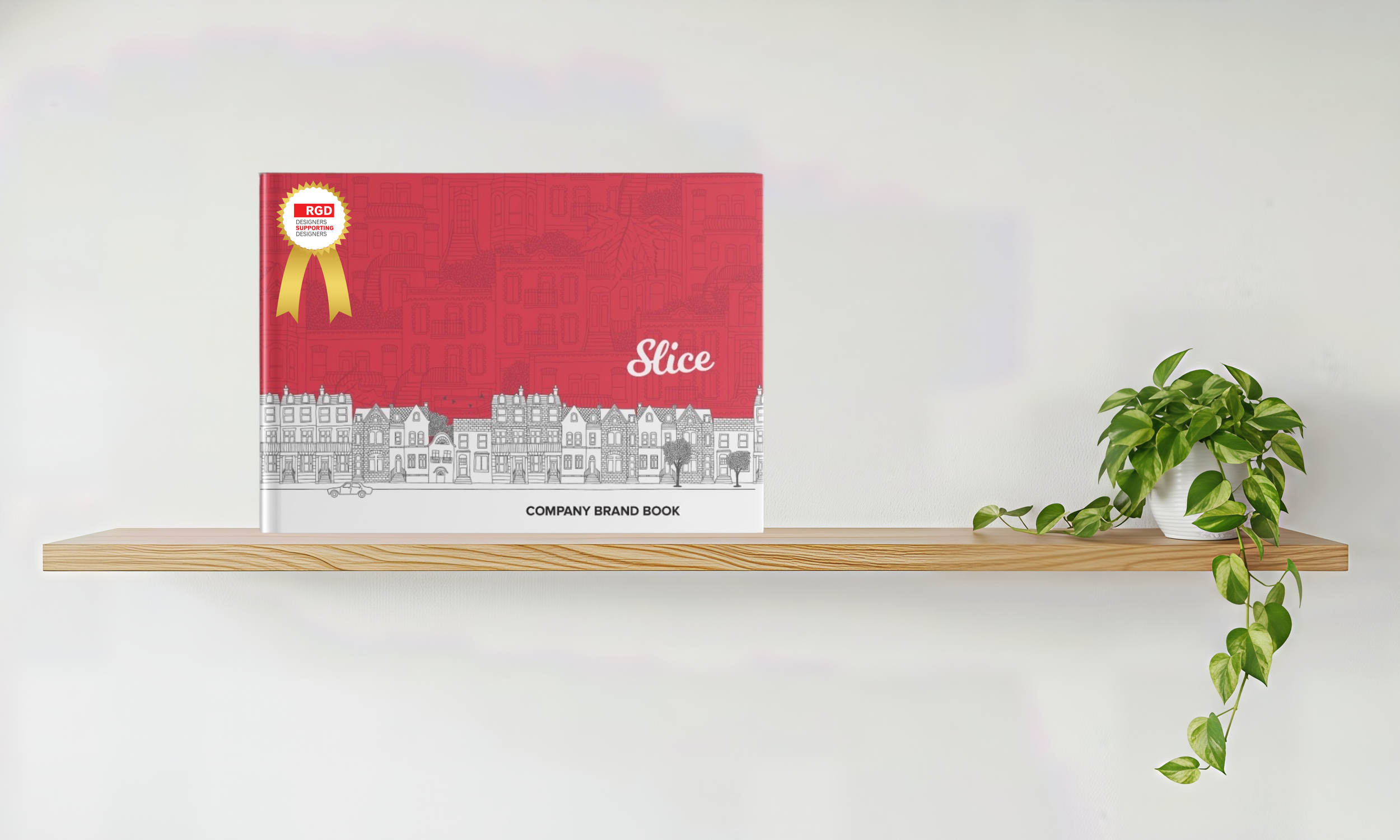 Red company brand book titled 'Slice' on a wooden shelf, with a small leafy potted plant on the right.