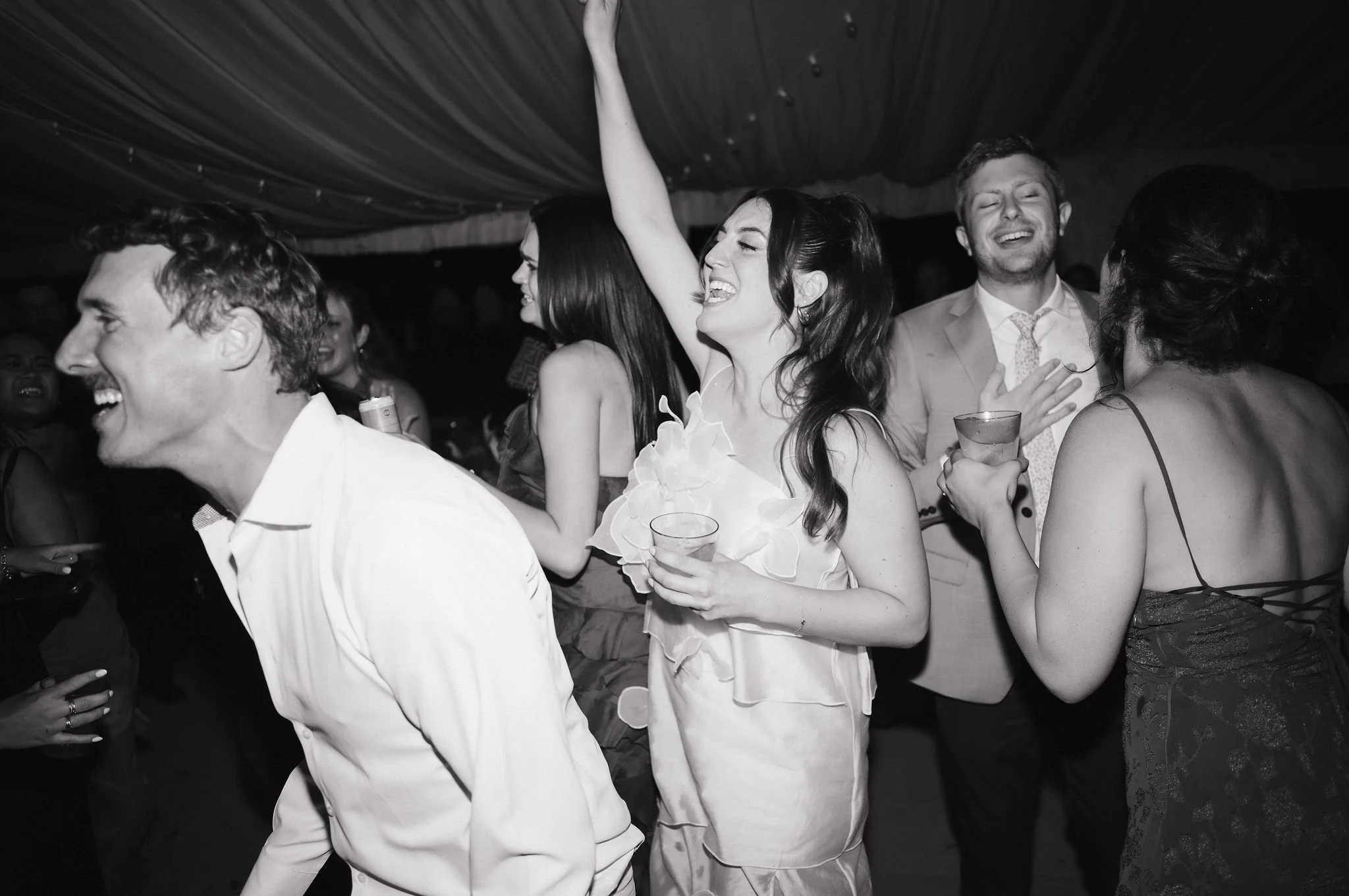 People dancing and celebrating at a lively party, smiling and enjoying themselves.