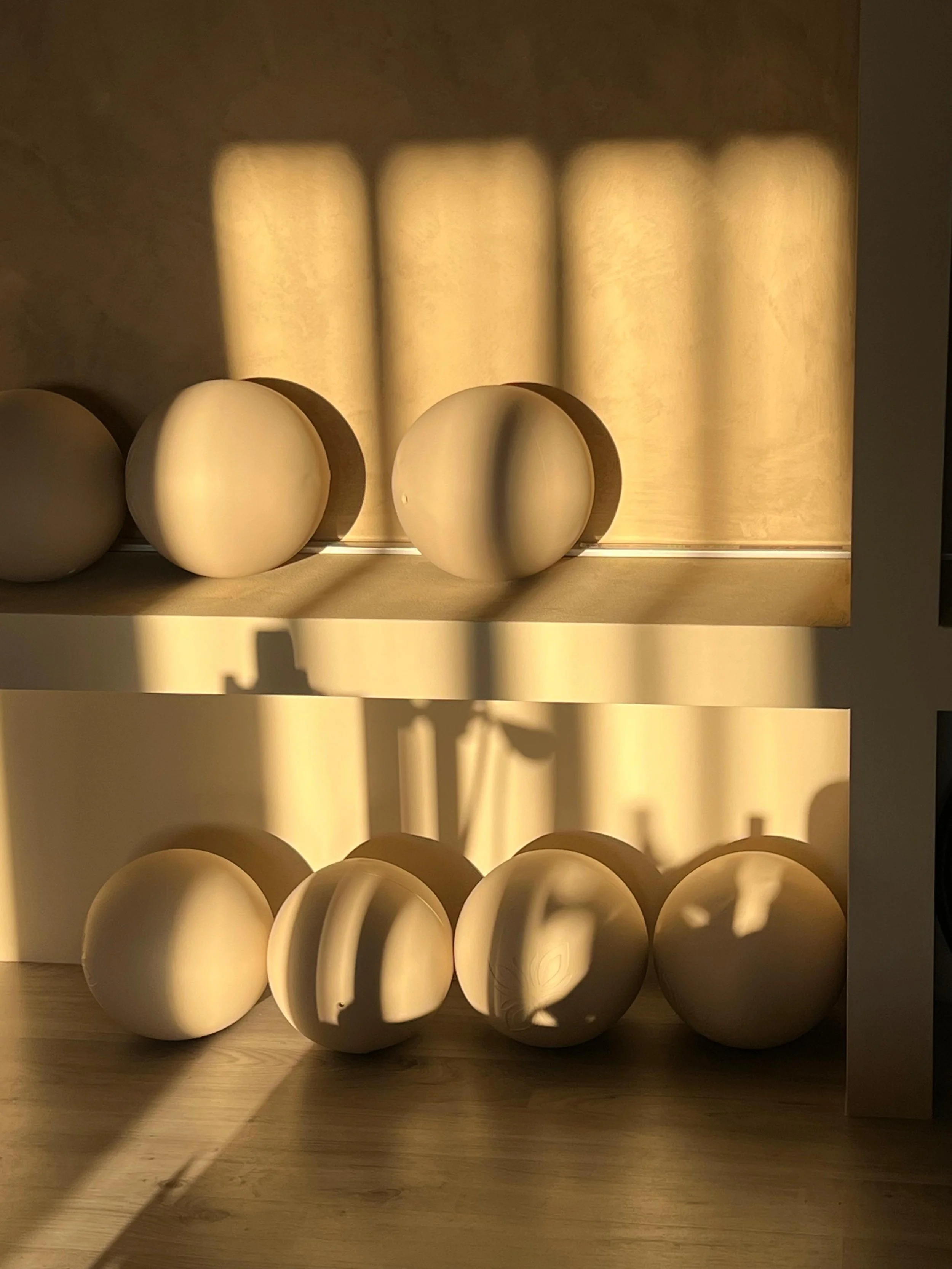 Set di sei uova di plastica bianche in una scatola di cartone, con luci che creano ombre e riflessi