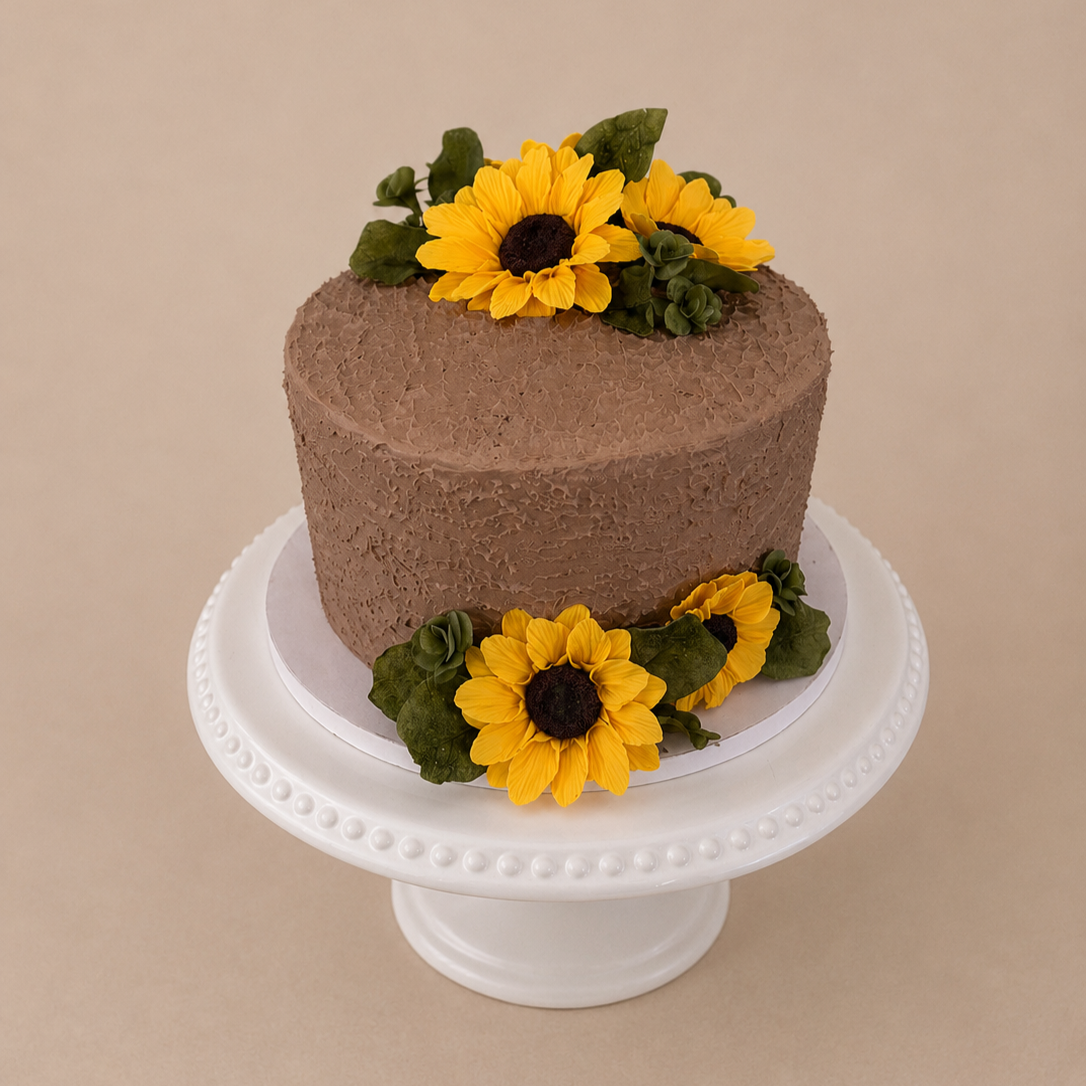 Beautiful handcrafted chocolate buttercream cake featuring realistic sunflower decorations and textured buttercream frosting. Designed by Graze & Glaze'd in Calgary, this custom cake is ideal for birthdays, weddings, bridal showers, baby showers, ann