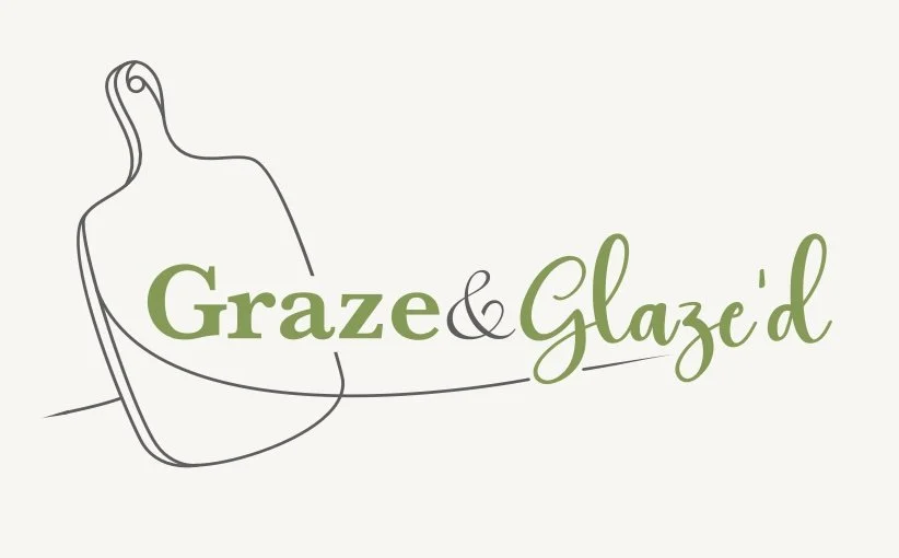A line drawing of a cutting board on a light background with the words 'Graze & Glazed' written next to it in green script and bold fonts.
