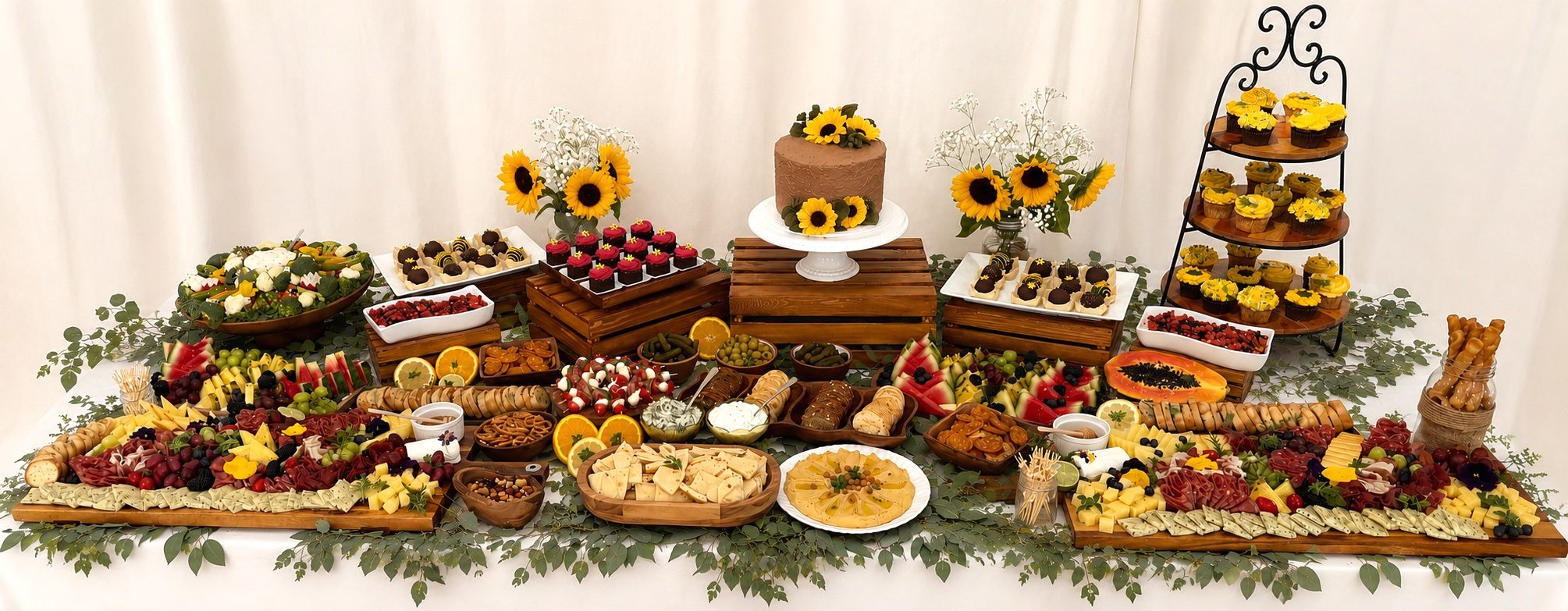 Elevated grazing and dessert table with charcuterie, artisan cheeses, fresh fruit, handcrafted desserts, sunflower cake, and cupcakes by Graze & Glaze'd in Calgary.