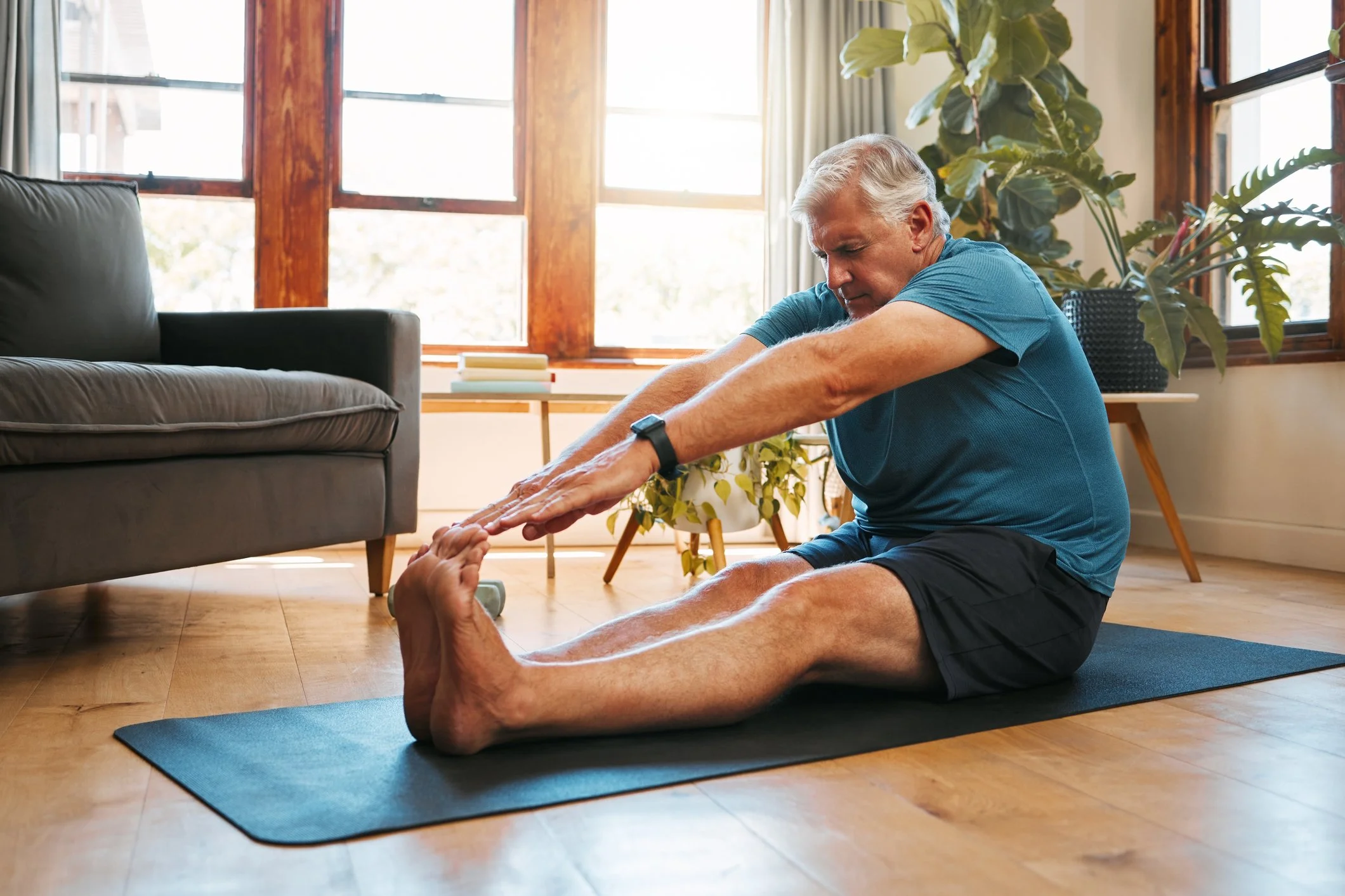 Gentleman struggling to stretch on his own, highlighting need for assisted stretching.