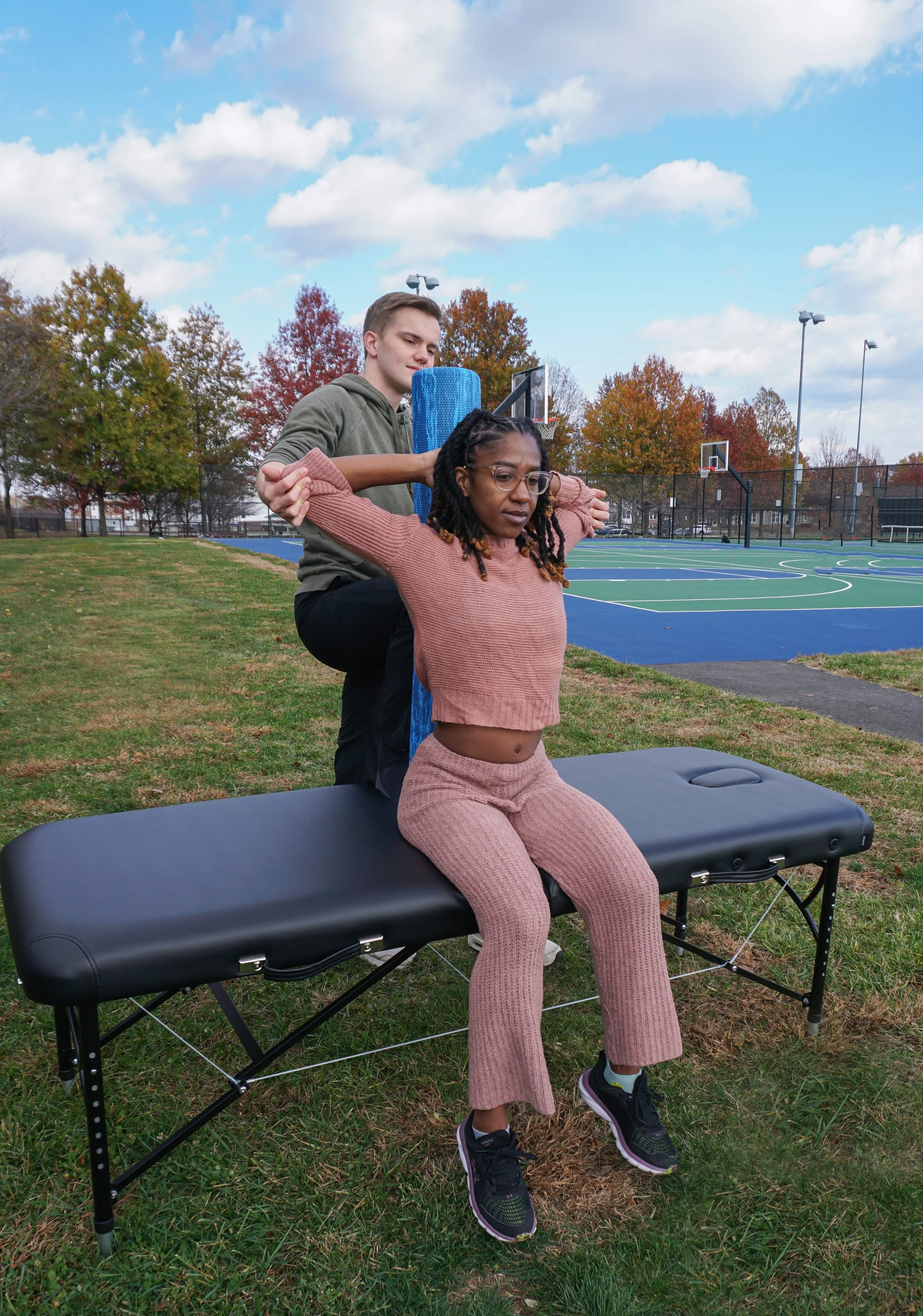 Assisted back stretch session outdoors improving spinal mobility and posture.
