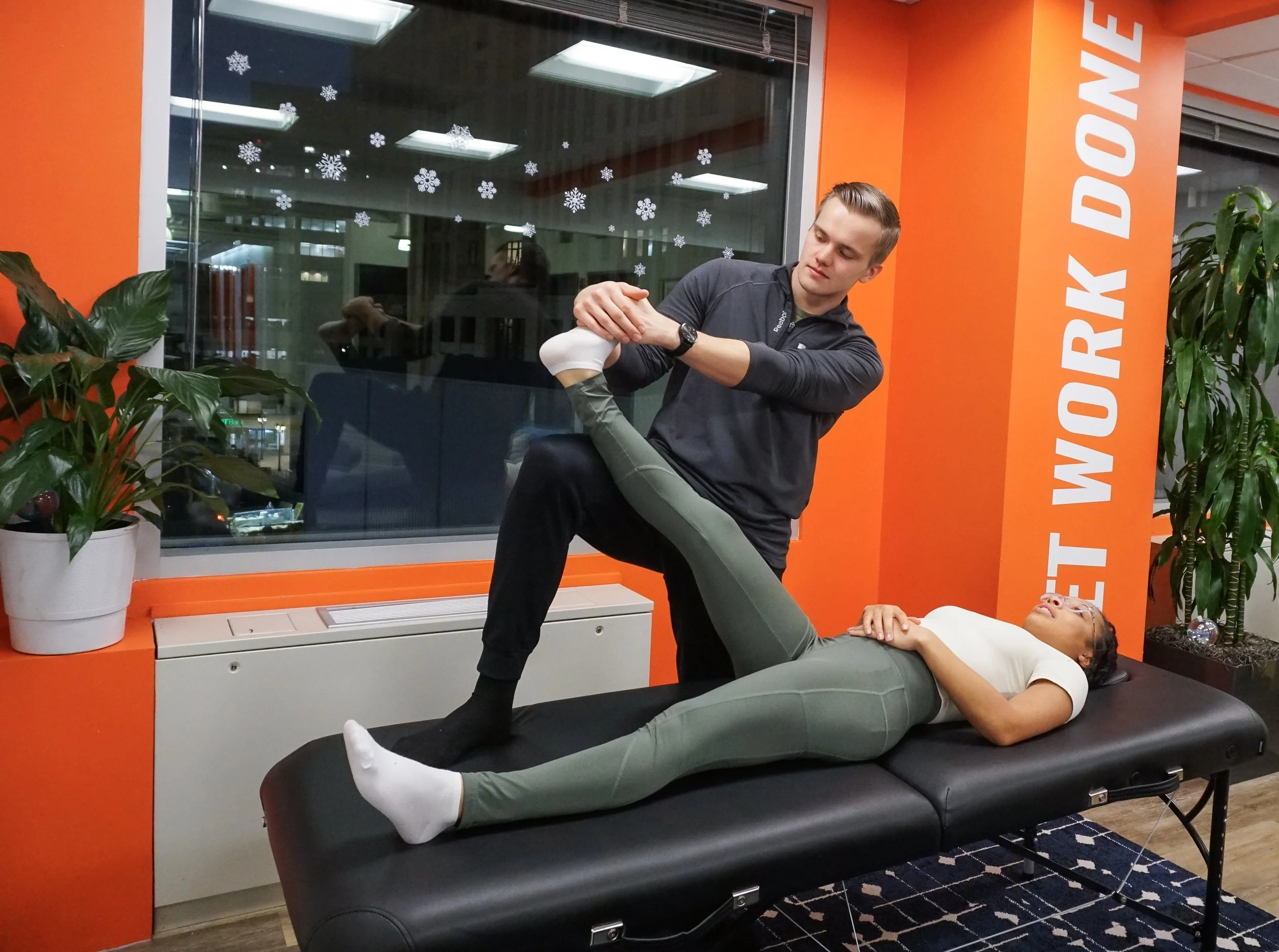 Assisted stretching therapist performing guided hamstring and hip stretch on client at Austin stretch studio.