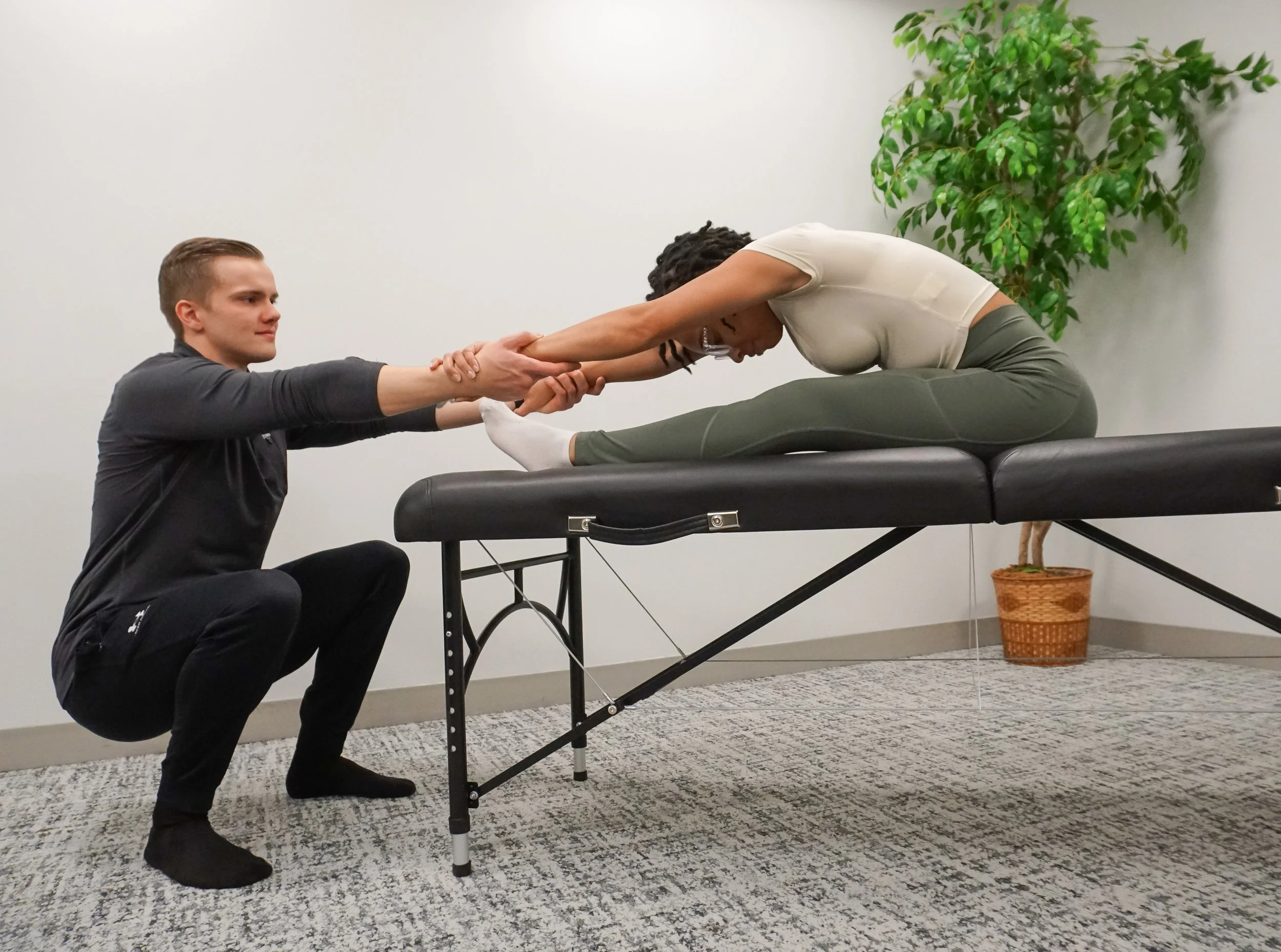 Professional assisted stretch therapist guiding client through full body stretch
