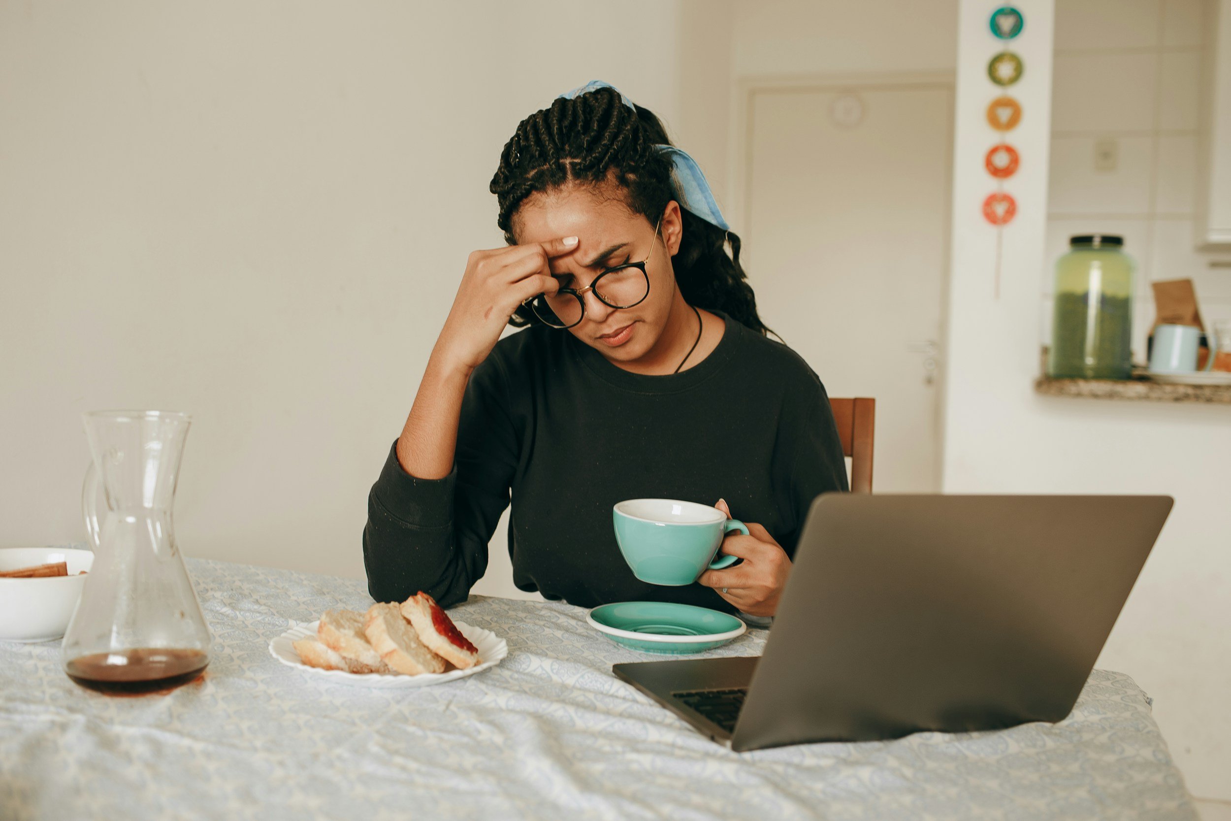 woman confused with hand on forehead holding a coffee cup lookin