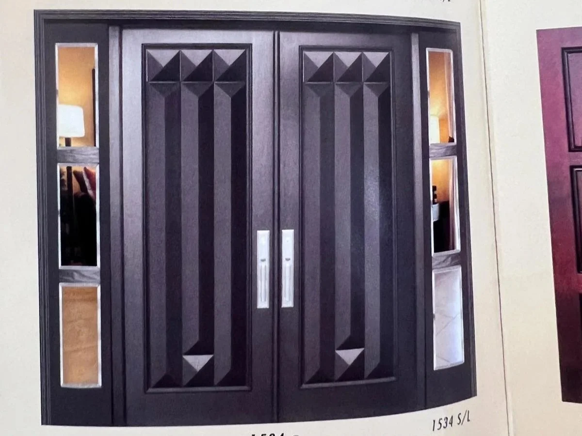 A dark wooden cabinet with geometric carved patterns on the doors and glass panels on each side, with inbuilt lighting inside.