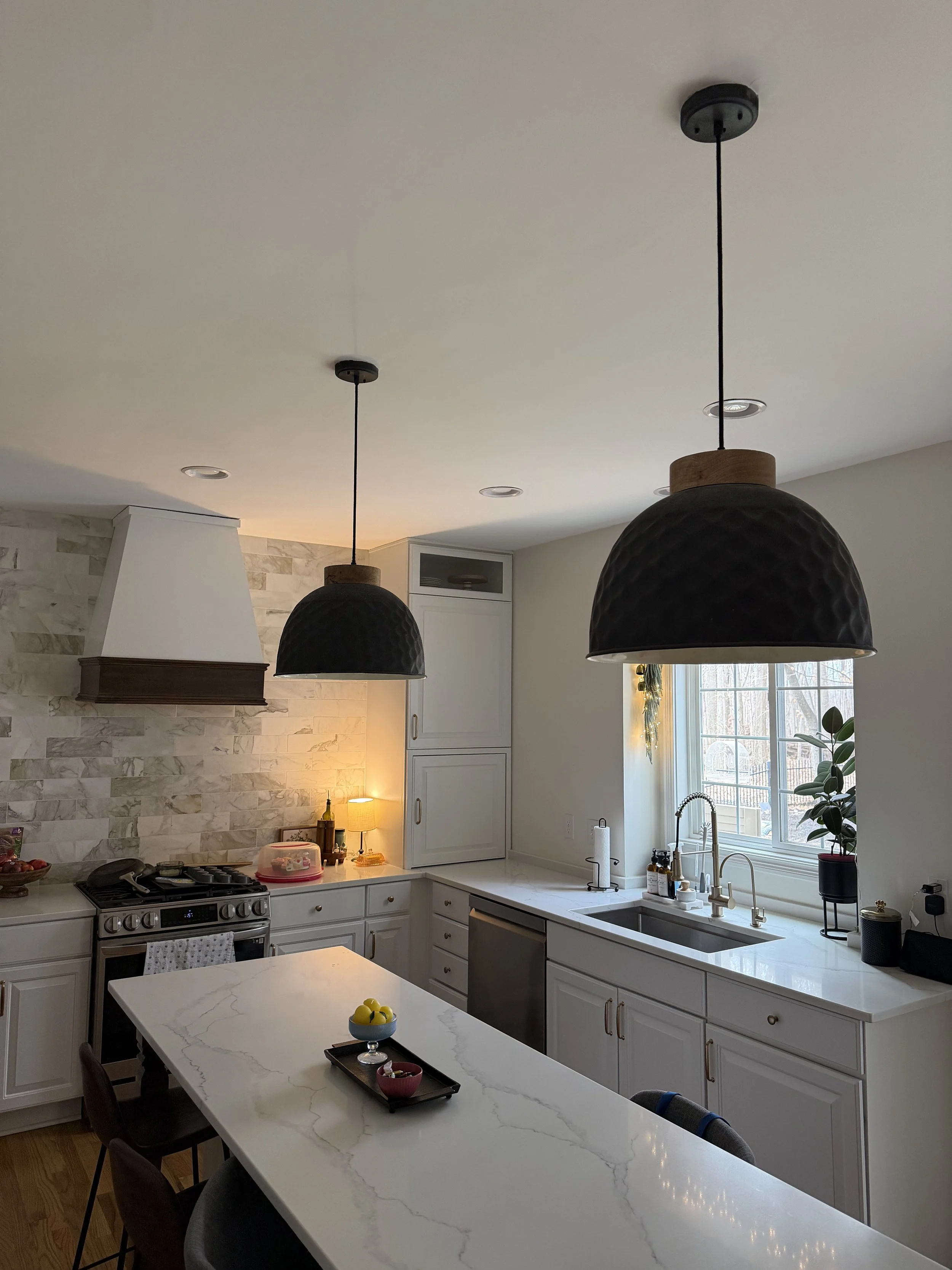 Installing high-end pendant lighting over a kitchen island in a Zionsville remodel.