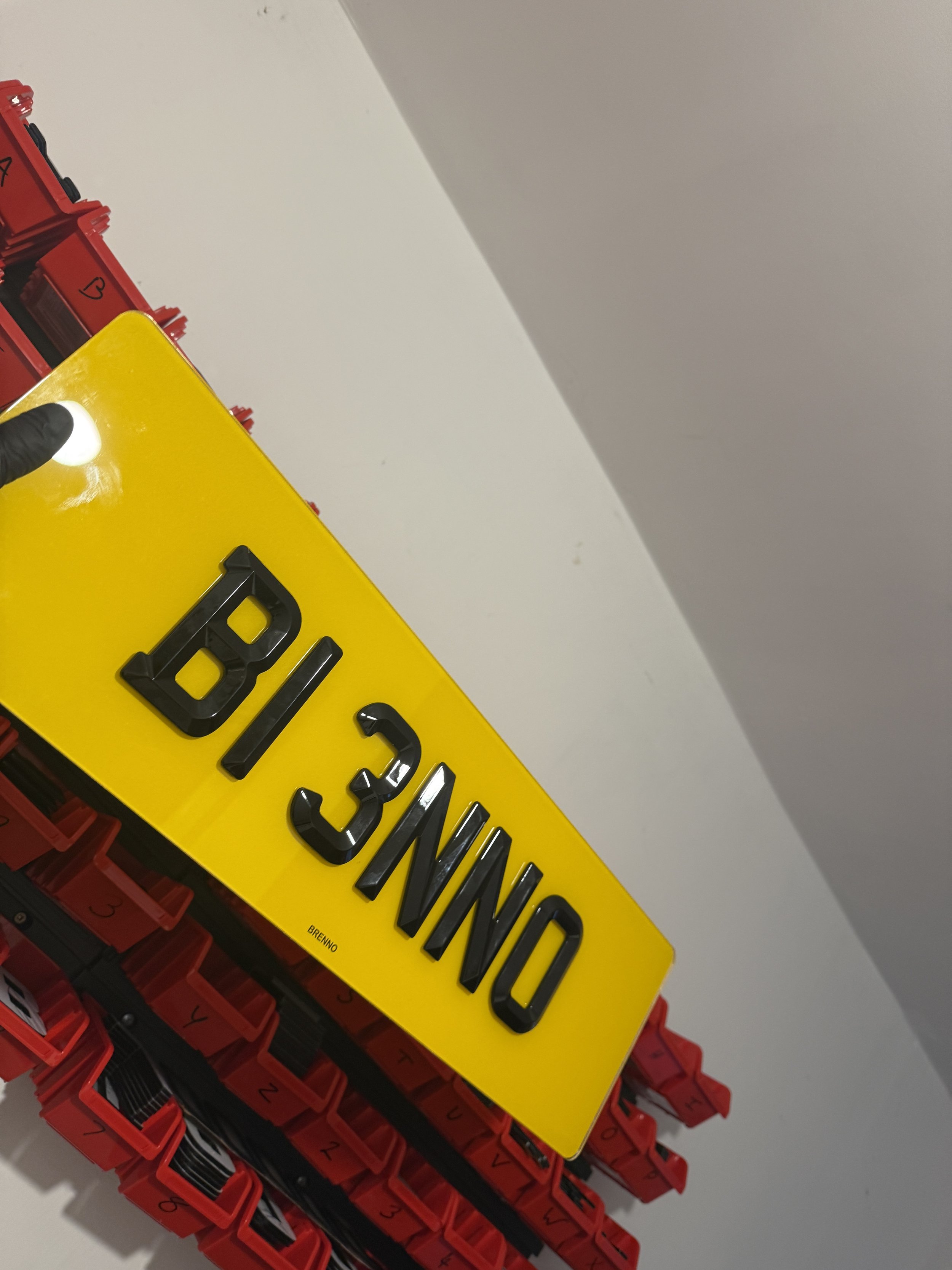 Yellow container with black magnetic letters spelling 'NO BILD 3' placed on red storage bins.