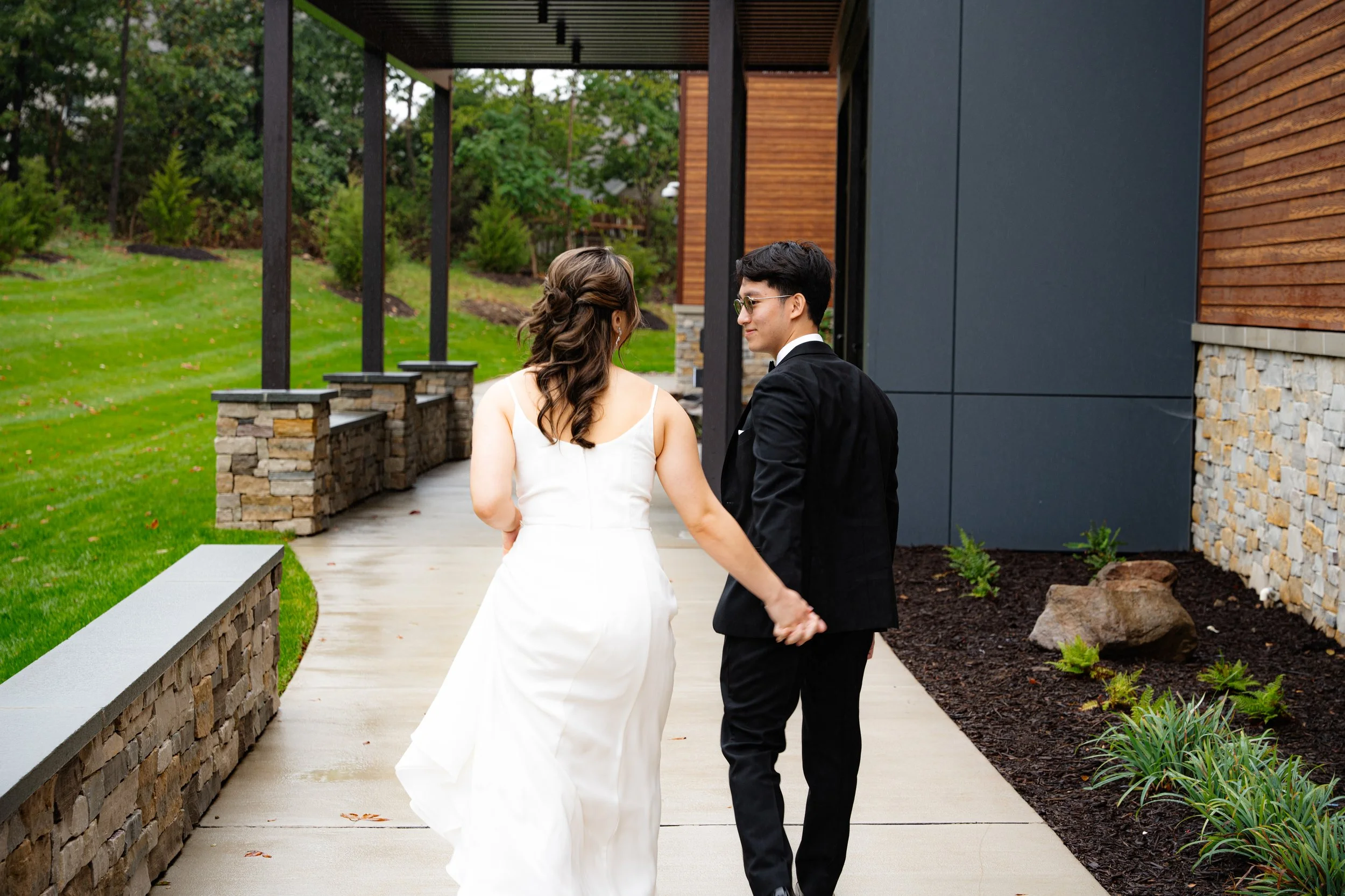 Laurie’s customers, Mariana and Carmen holding hands on a green lawn on their wedding day.