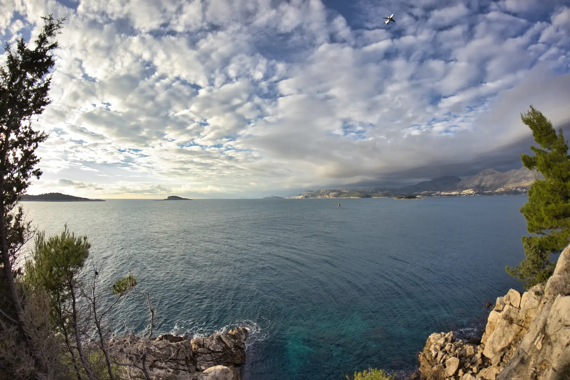 Beautiful evening clouds and scenic coastline view from a boat in Cavtat.