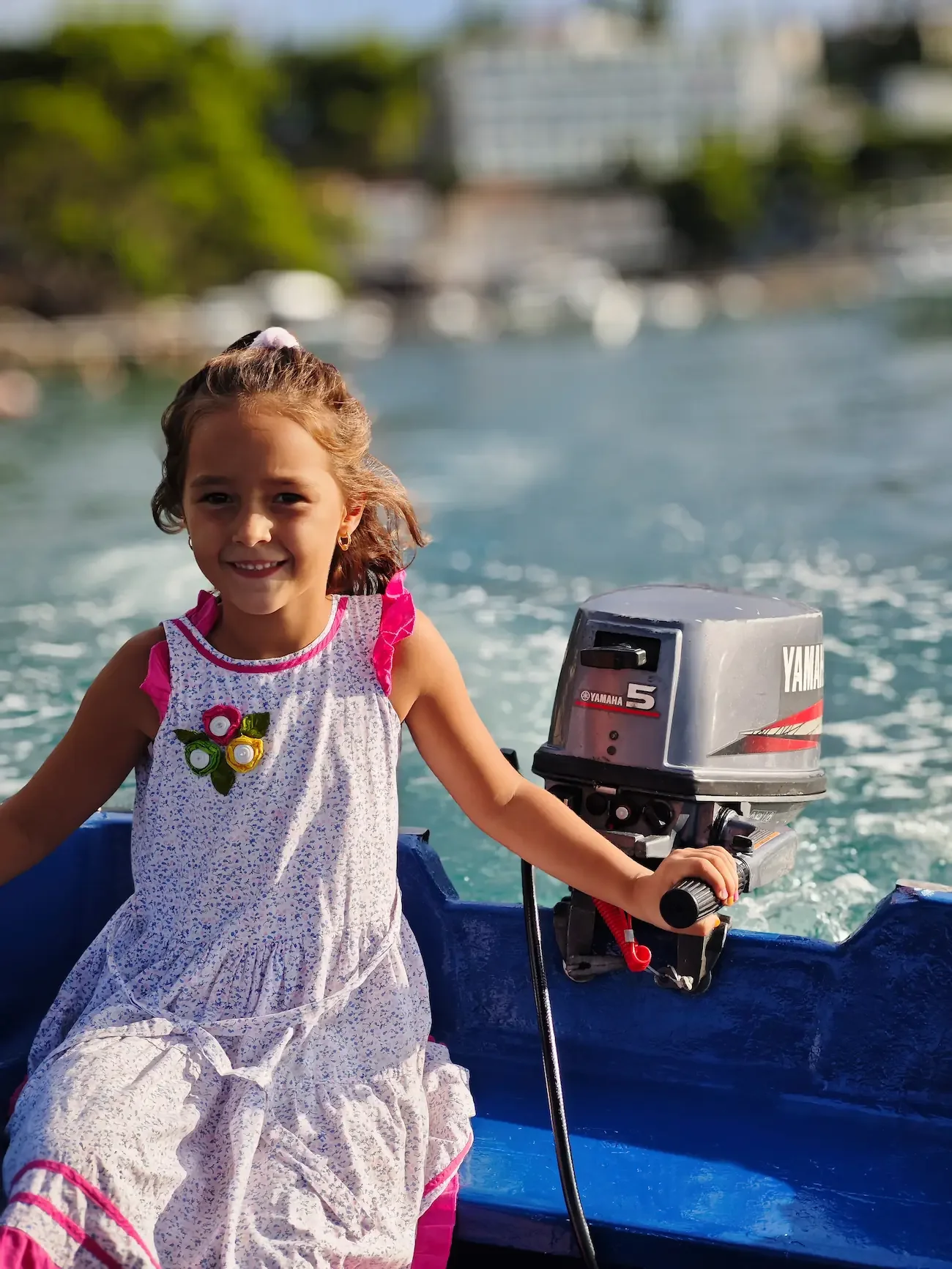 A young girl smiling while sitting in a boat with a Yamaha outboard motor, safe boat rental experience for families exploring the bays around Cavtat.