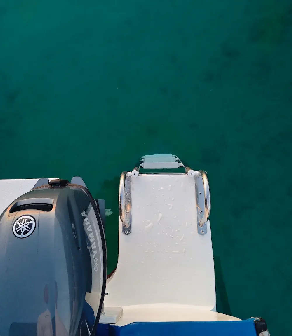 Swim ladder on a rental boat over crystal clear turquoise sea in Cavtat.