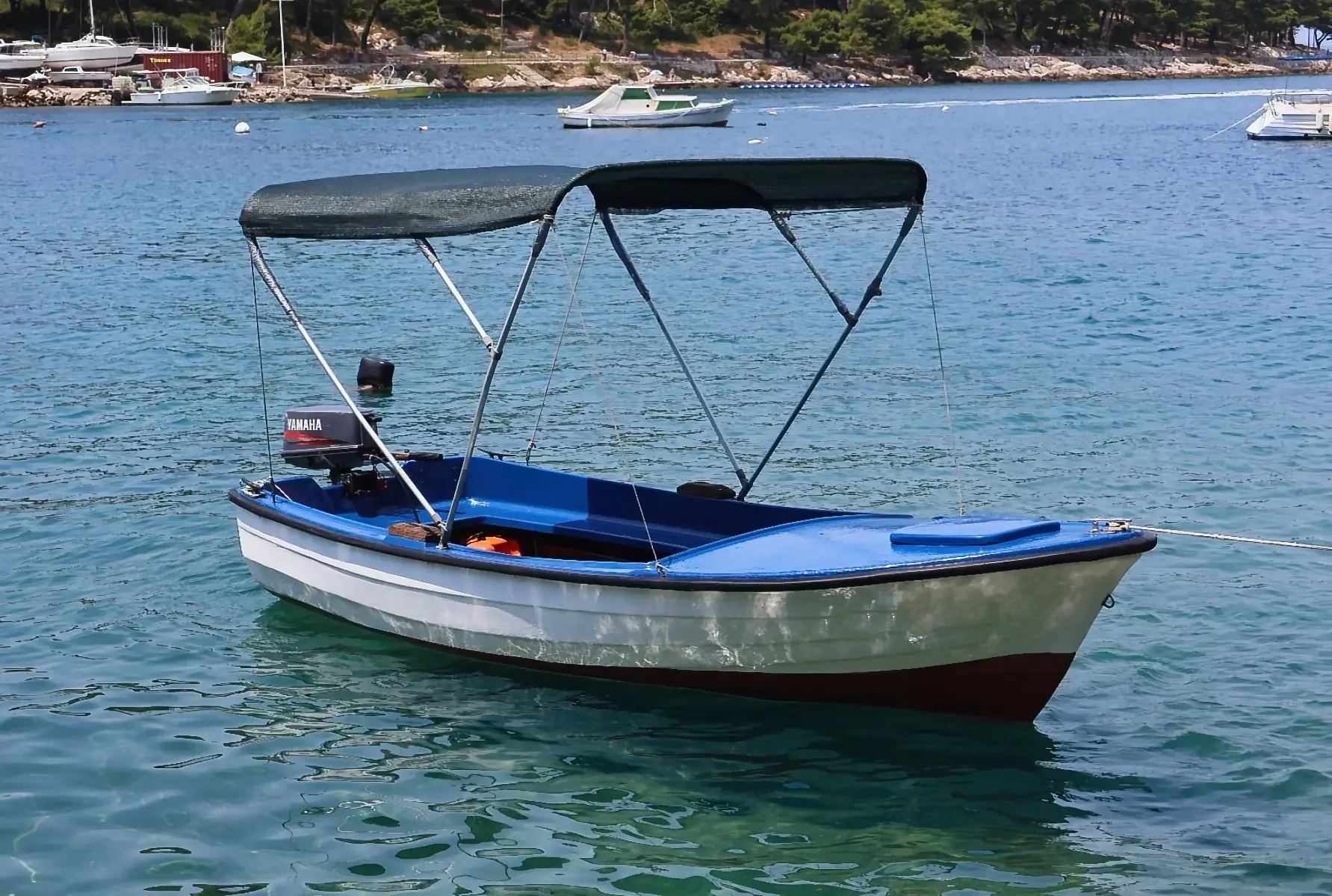 Local Boats Cavtat - Blue Pasara boat with sunshade in clear turquoise water.