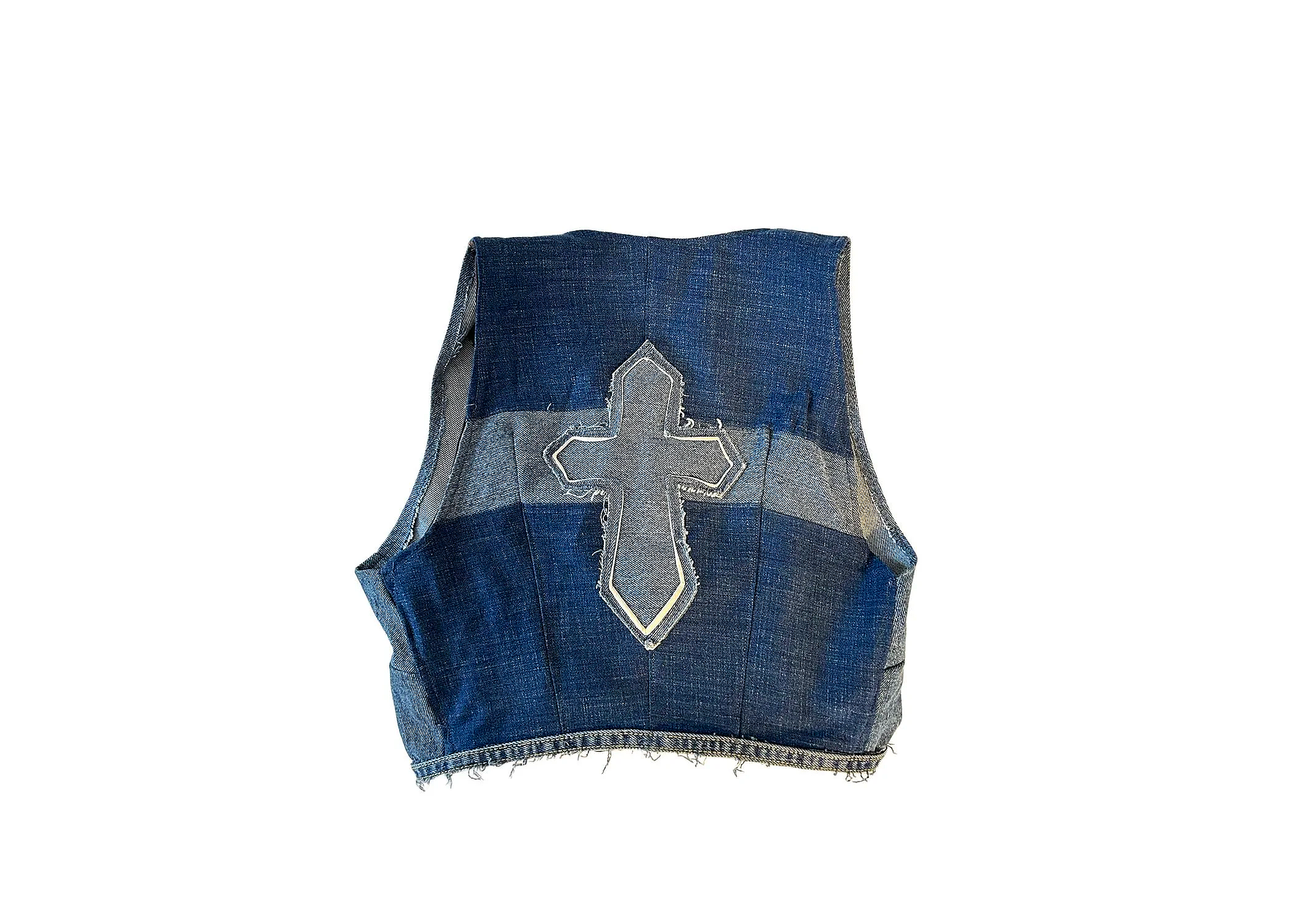 Rear view of recycled denim vest. The back of this vest features a custom cross applique with inverted lined layers. The construction consists of lateral panels of varying denim washes as well as rear darts for fit. Bottom trim detail on the front an