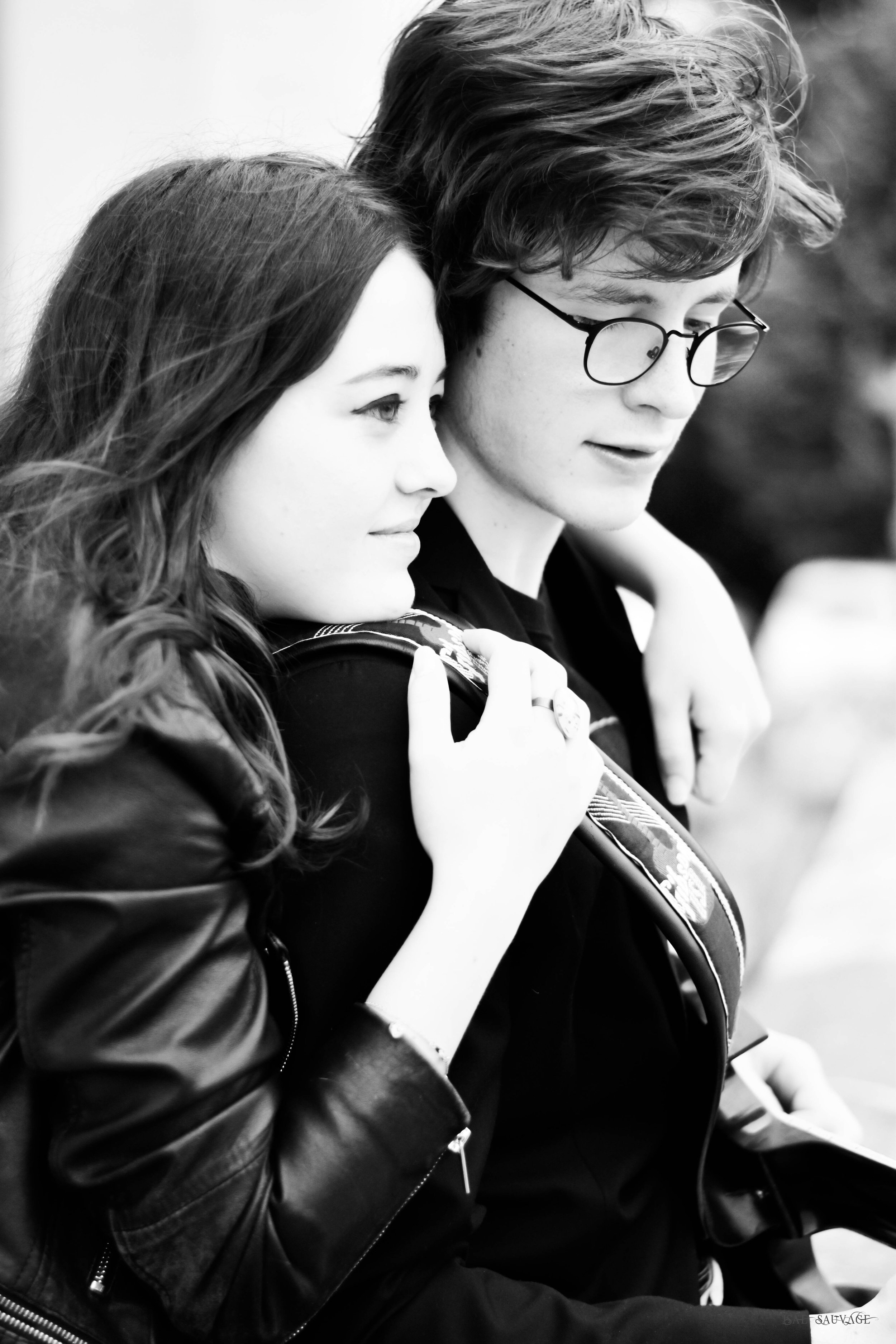 Un homme et une femme regardent la guitare que tient l'homme, l'un porte des lunettes et l'autre une veste en cuir.