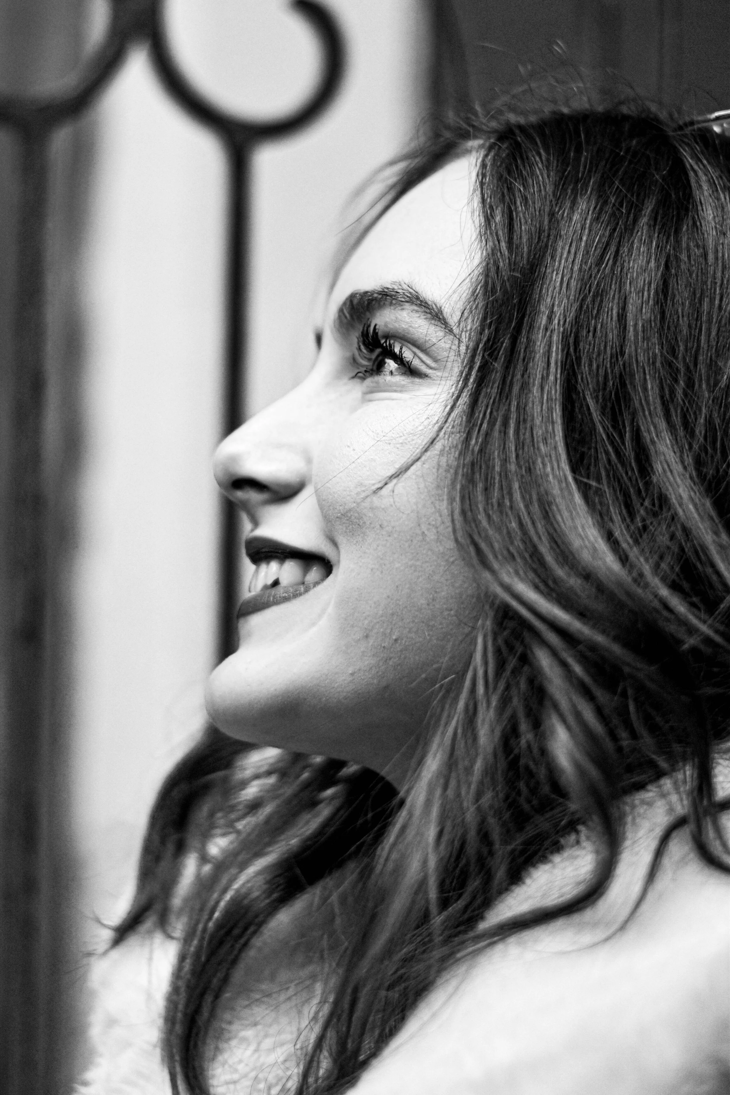 Portrait en noir et blanc d'une femme souriante avec des cheveux longs et ondulés.