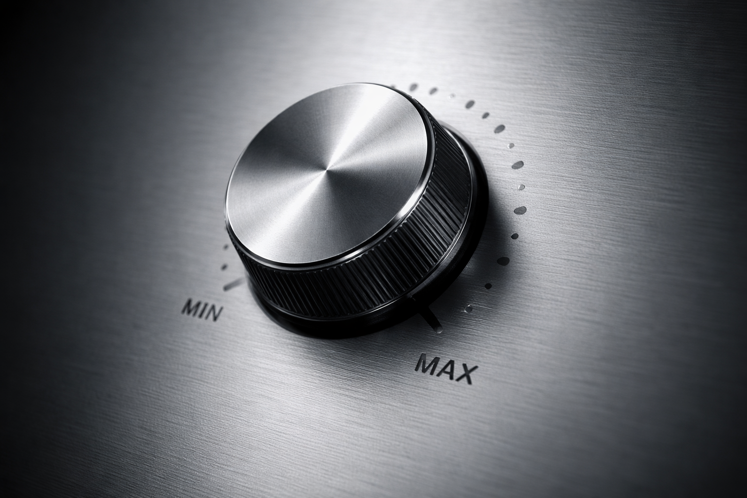 A close-up of a metallic control knob set to maximum on a stainless steel appliance, with a textured ridged edge and a surrounding scale marked from MIN to MAX.
