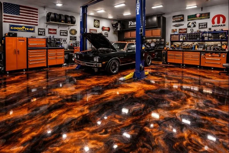 Inside an auto repair shop with a black classic car on a lift, open hood, surrounded by orange tool cabinets, wall-mounted tires, and automotive posters. The polished epoxy, patterned floor reflects the overhead lighting.
