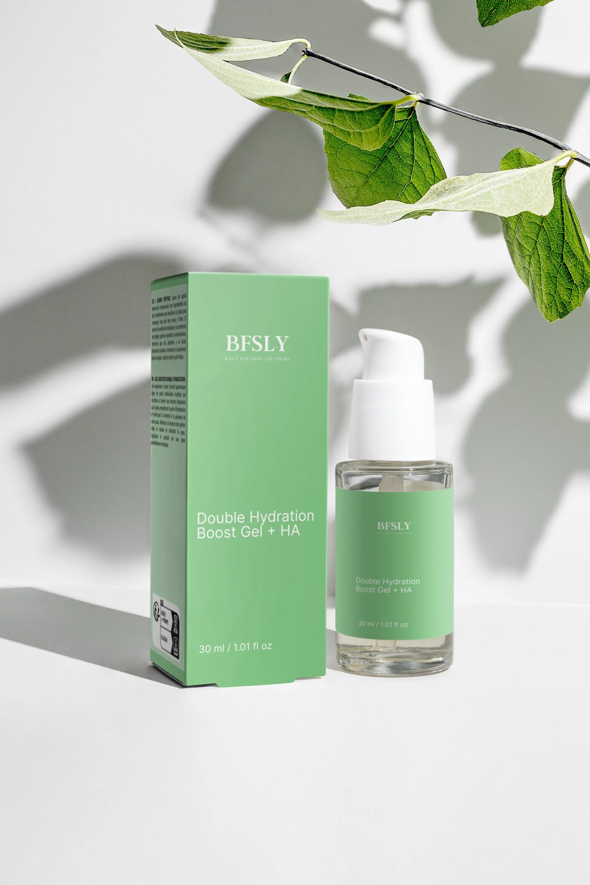 Hand holding a green and white bottle of moisturizing cream with pump dispenser against light green background.