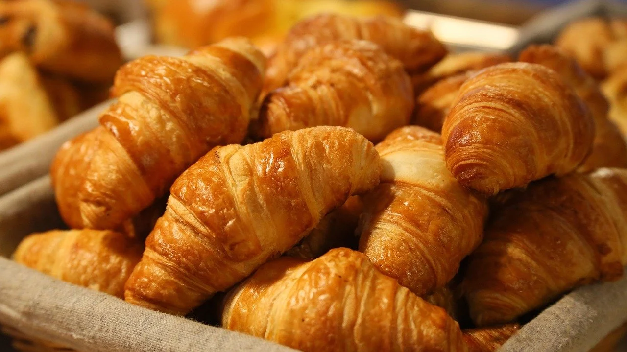 Freshly baked croissants in a basket.