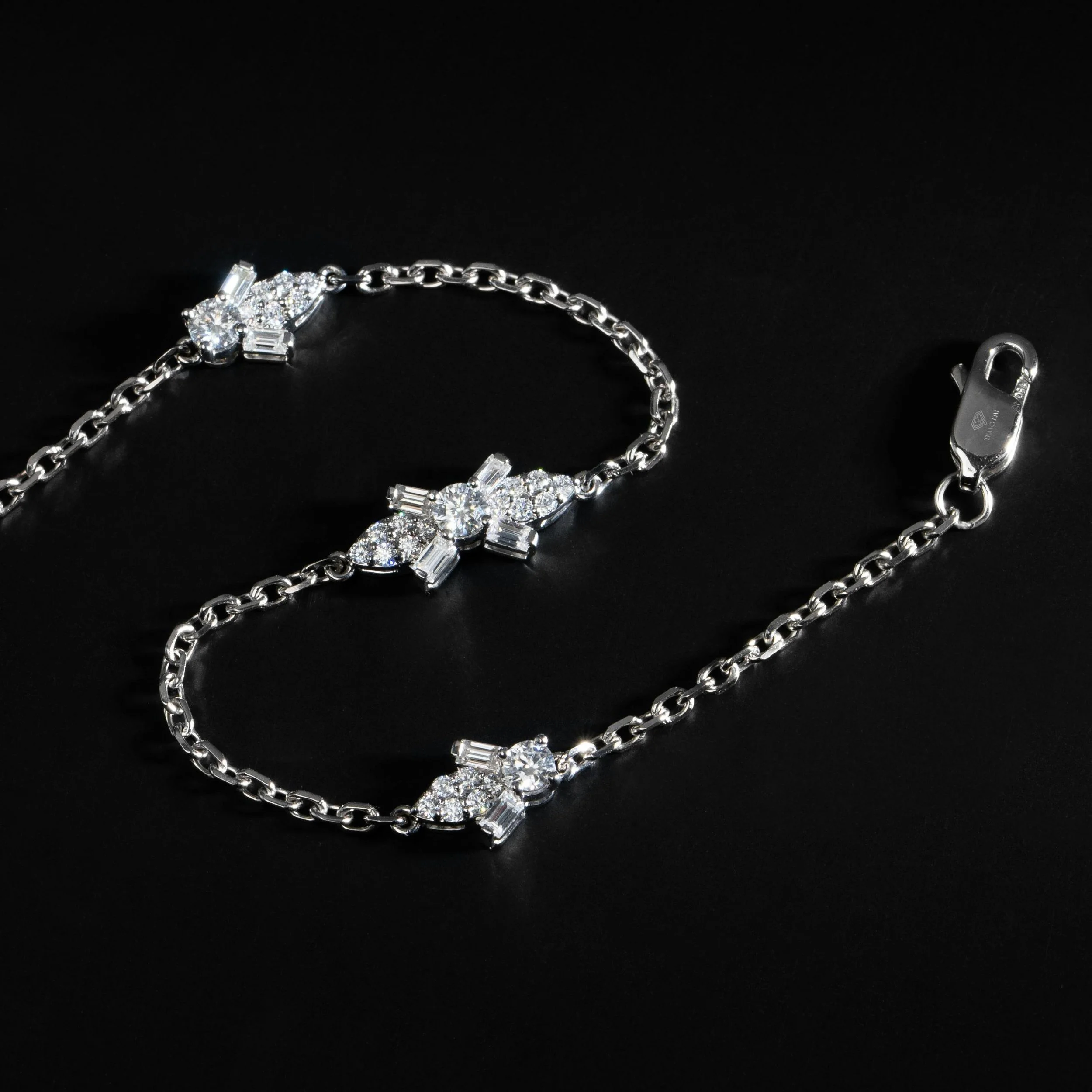 Elegant silver bracelet with sparkling diamonds laid on a black background