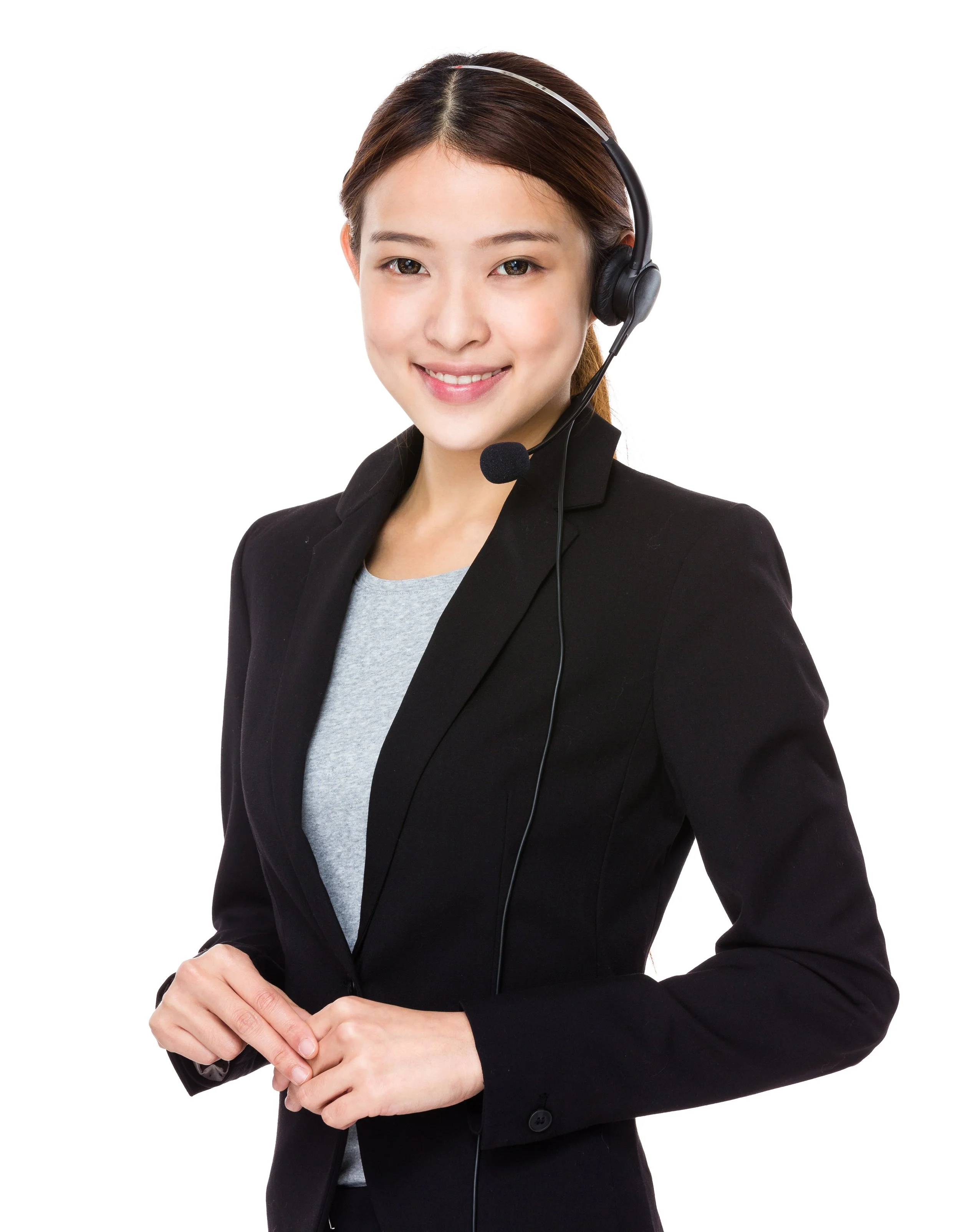 A woman in a black blazer and gray shirt wearing a headset with a microphone, standing against a white background.