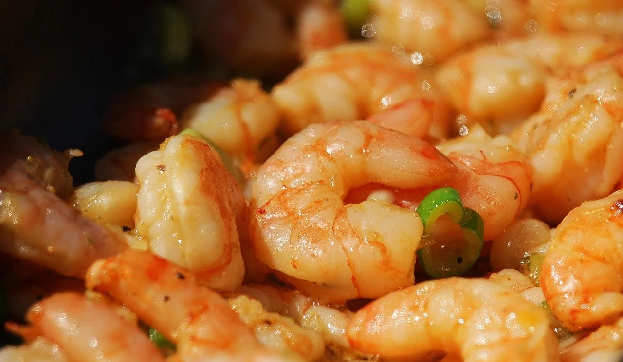 Close-up of cooked shrimp with some green garnish.