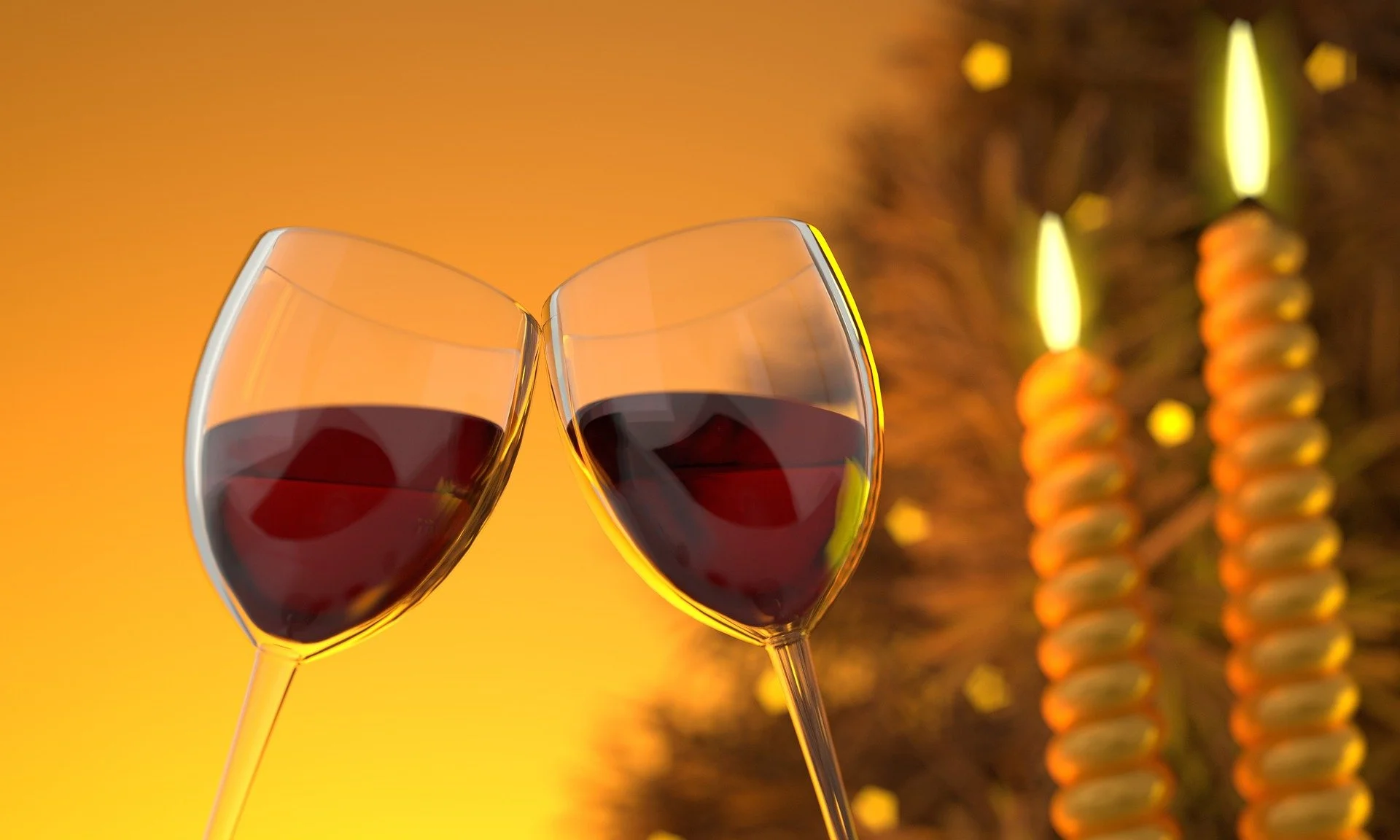 Two glasses of red wine clinking against a warm, orange background with blurred Christmas lights and ornaments.