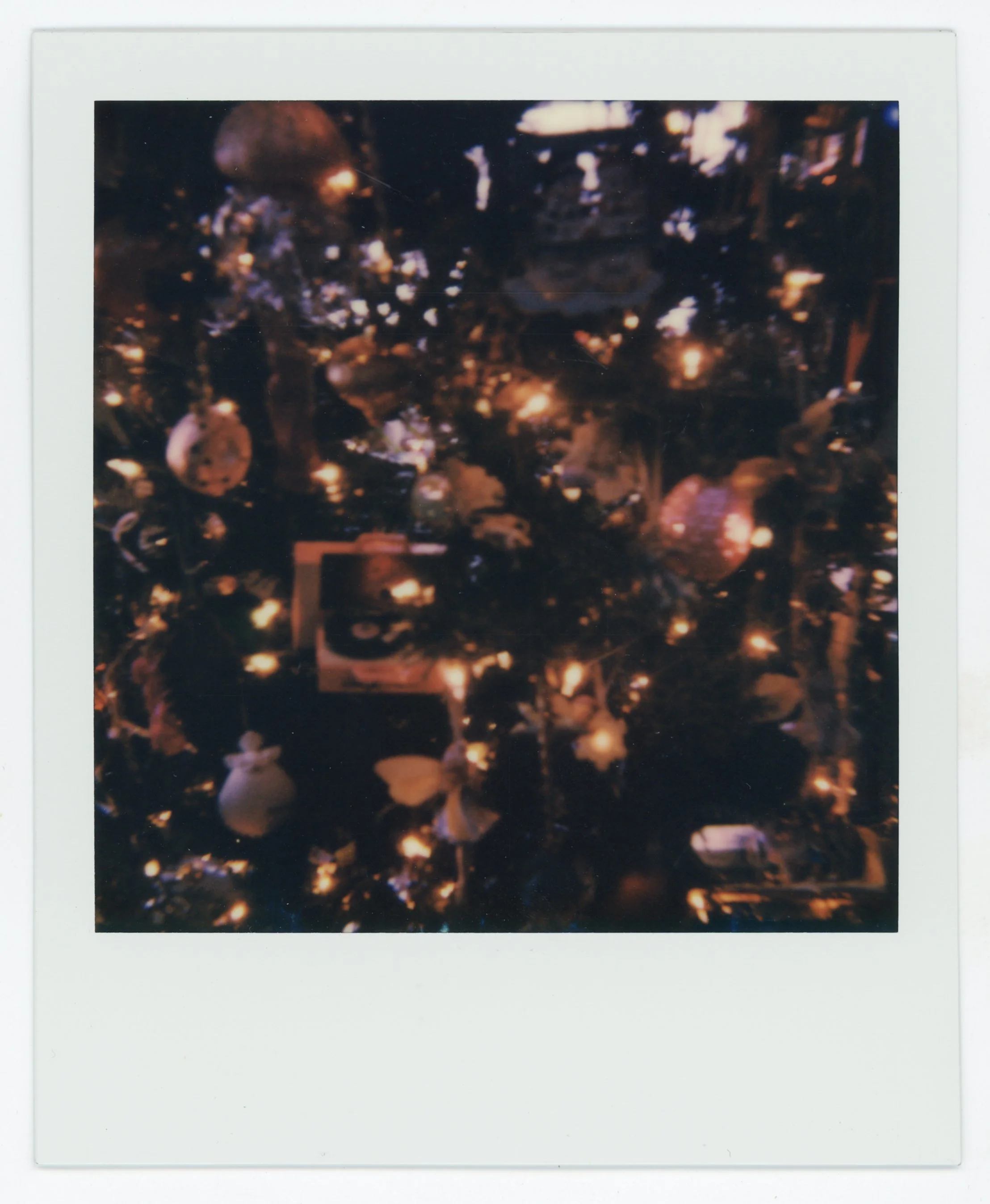 Blurry image of a decorated Christmas tree with lights and ornaments.