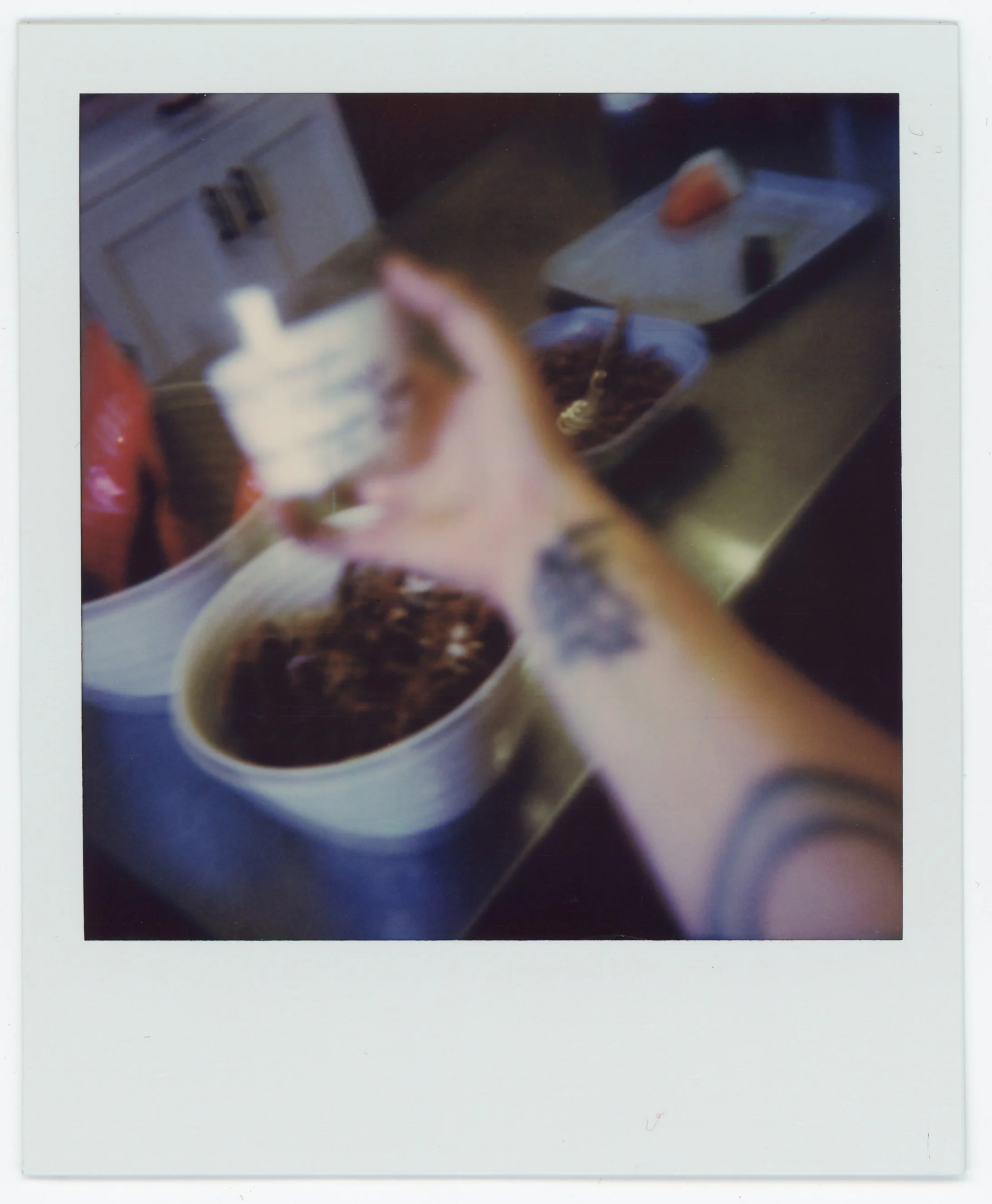 A person pouring cream into a cup of coffee.