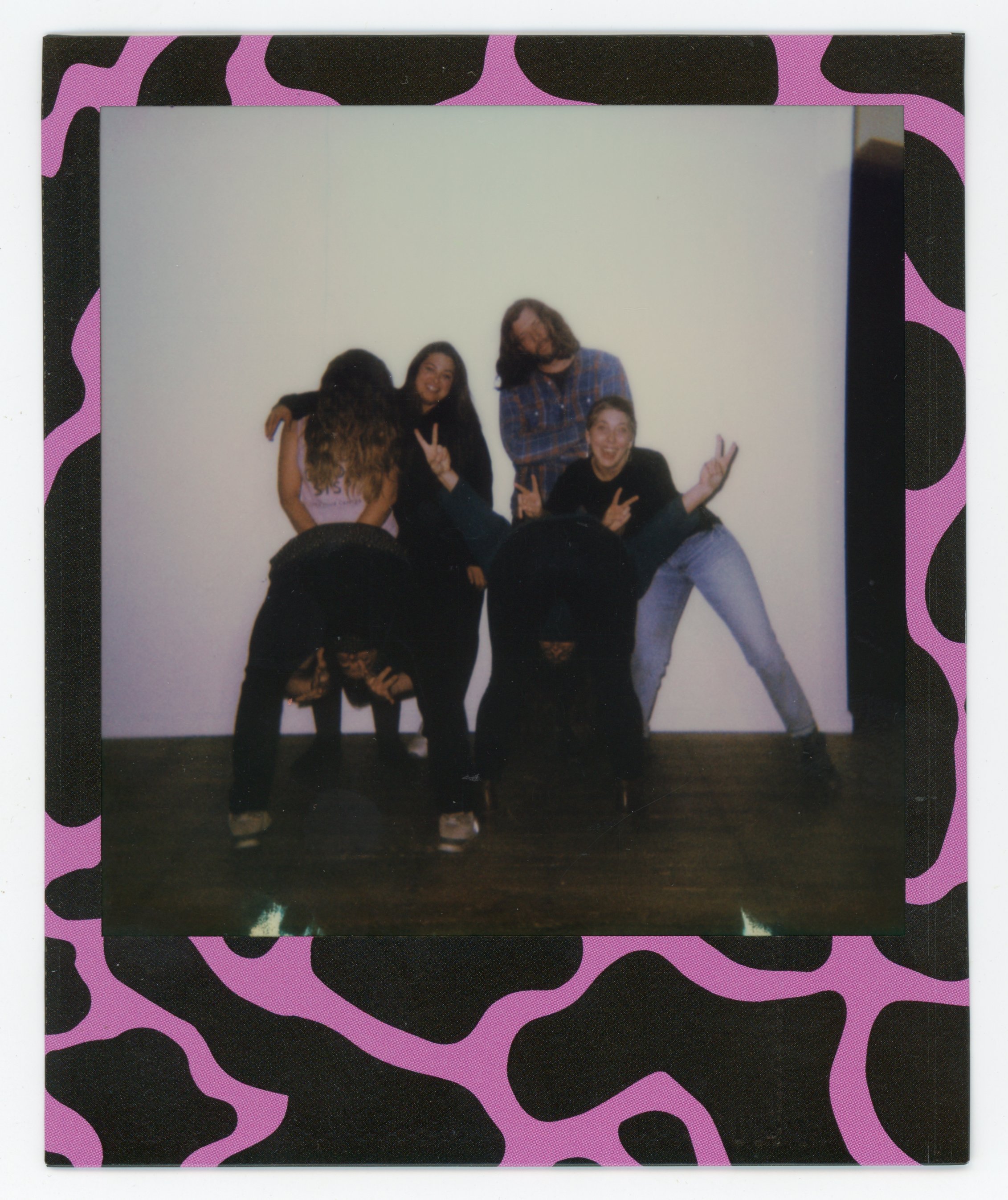 Five people posing and making peace signs in front of a white wall, framed with a pink and black leopard print border.
