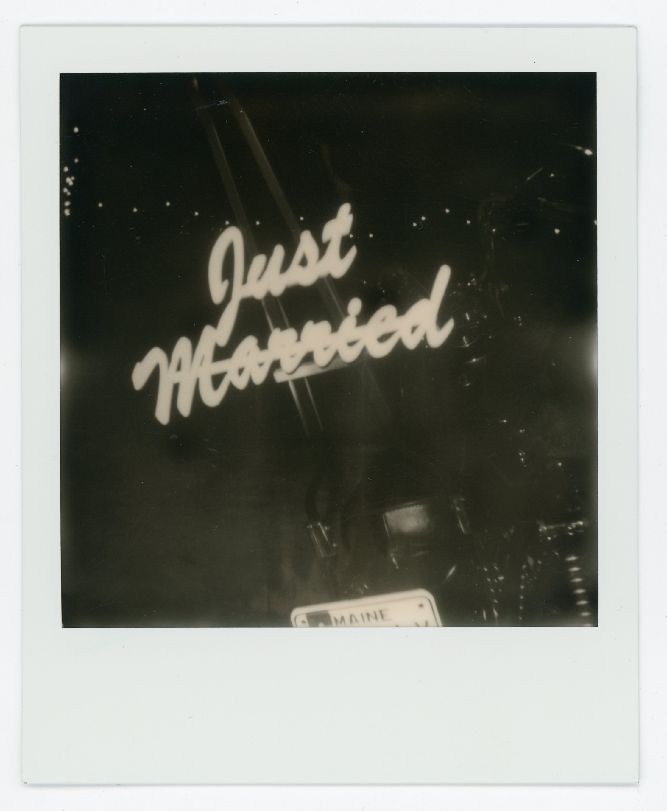Neon sign reading 'Just Married' with a Maine license plate at the bottom.