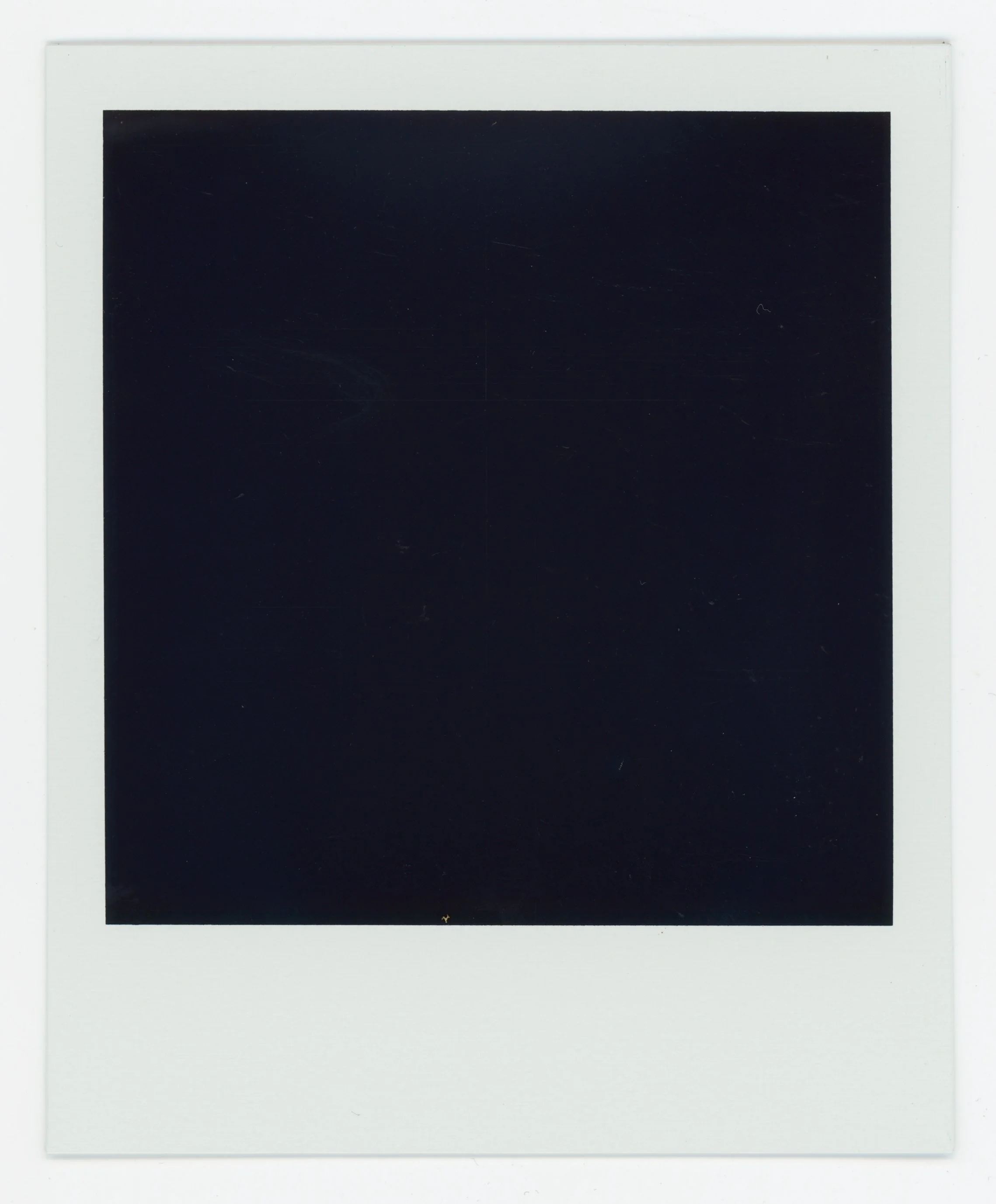 Blank black square in the center of a white Polaroid frame.