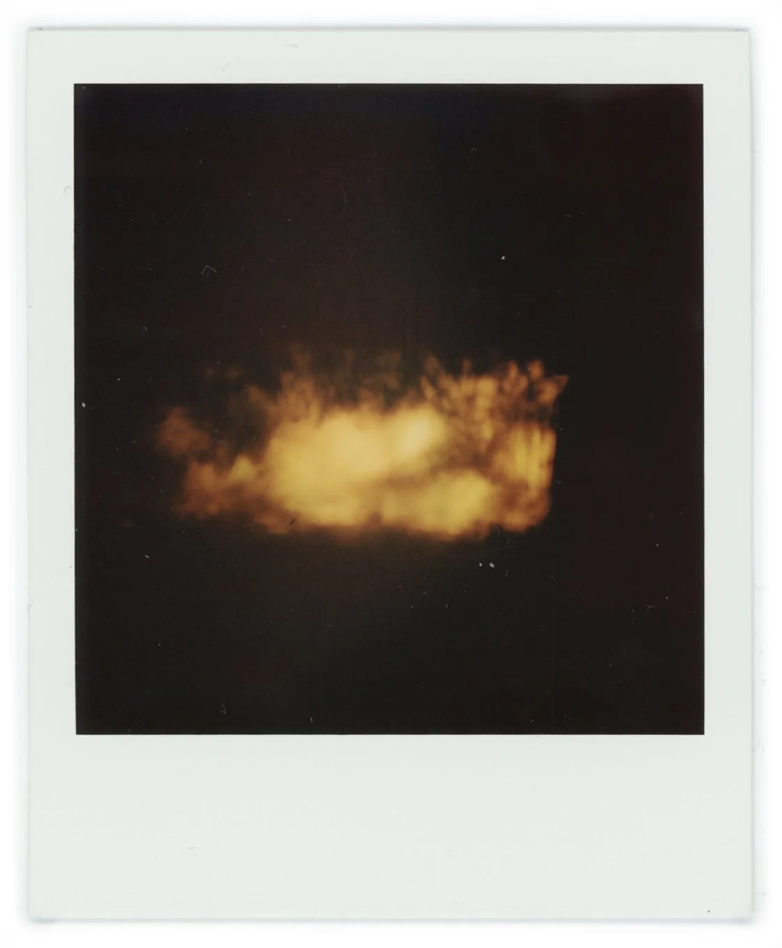 Nighttime view of a large explosion with a fiery, billowing cloud in the dark sky.