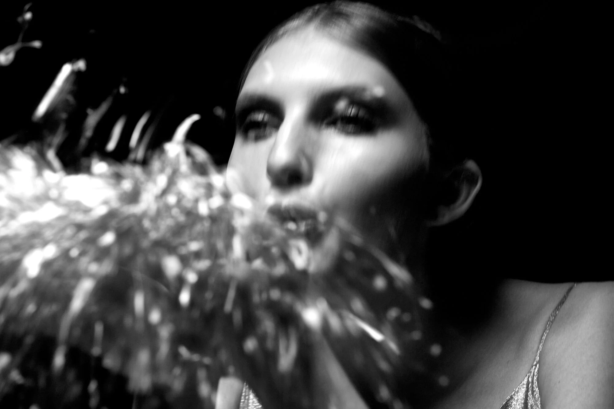 A woman with long hair kissing a bouquet of flowers.