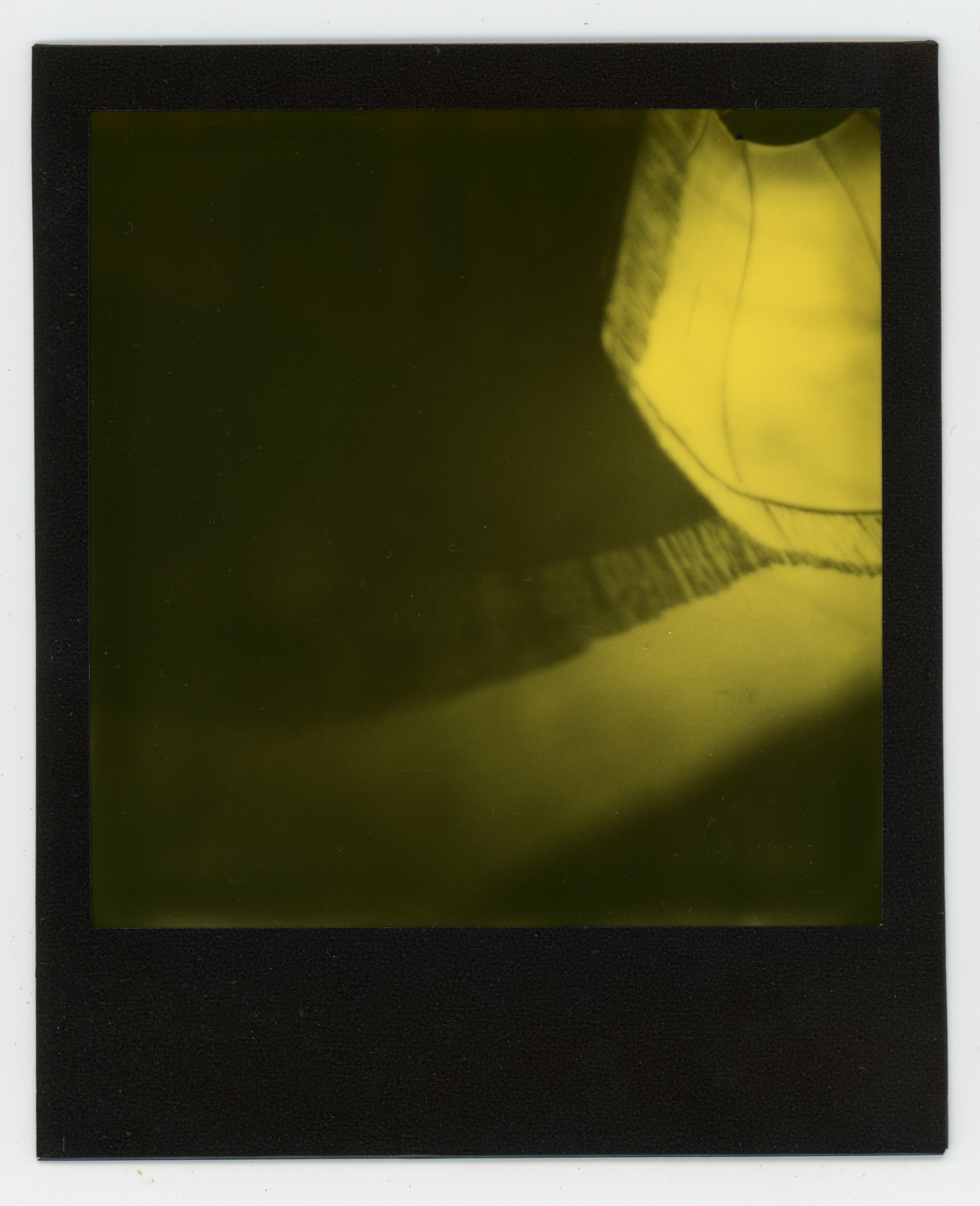 Close-up of a black-and-yellow object with shadows and fabric texture.