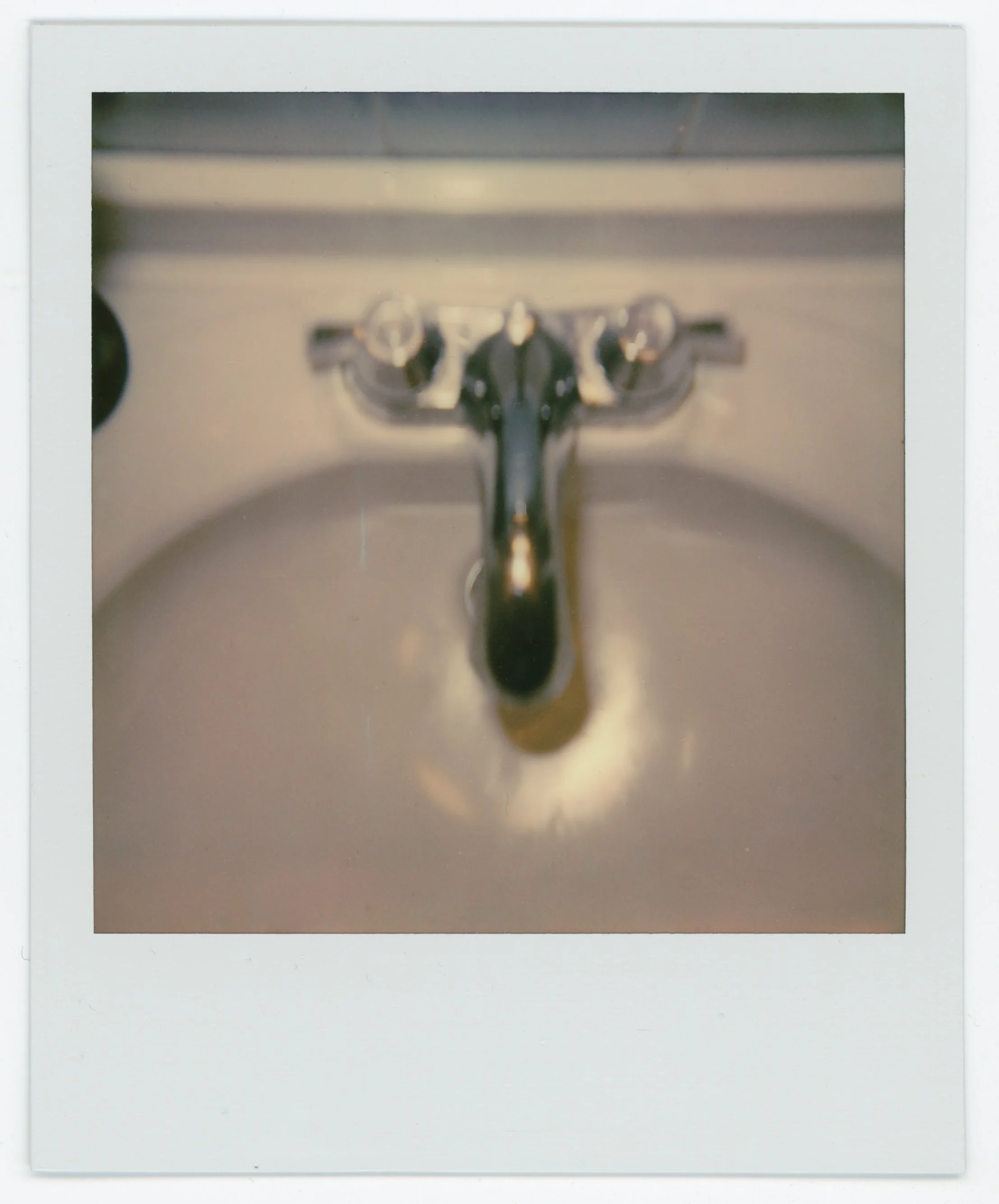 Close-up photo of a bathroom sink faucet with water running.