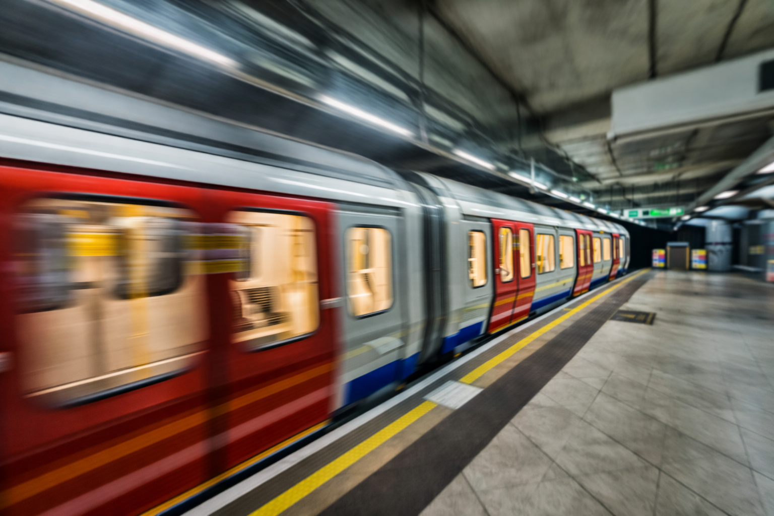 A moving train in an underground subway station with motion blur
