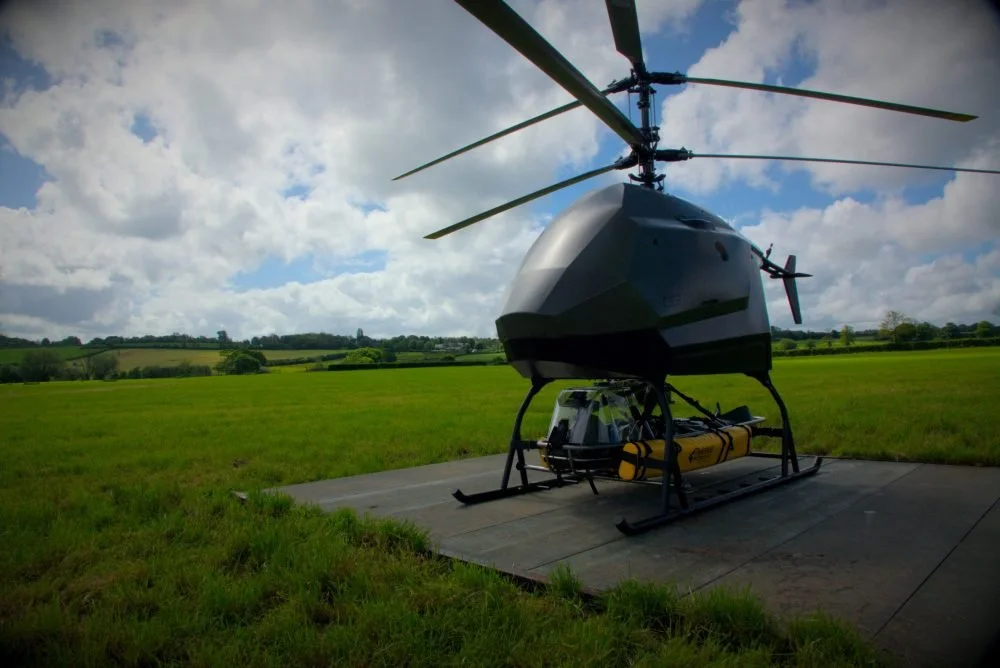 CERTO A helicopter with a large drone-like appearance sitting on a grass field. Technical Composites for aerospace.