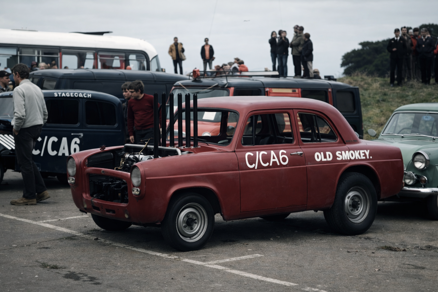 Vintage red race car with open hood and custom exhaust pipes, parked among other classic cars at an outdoor car show with people observing.